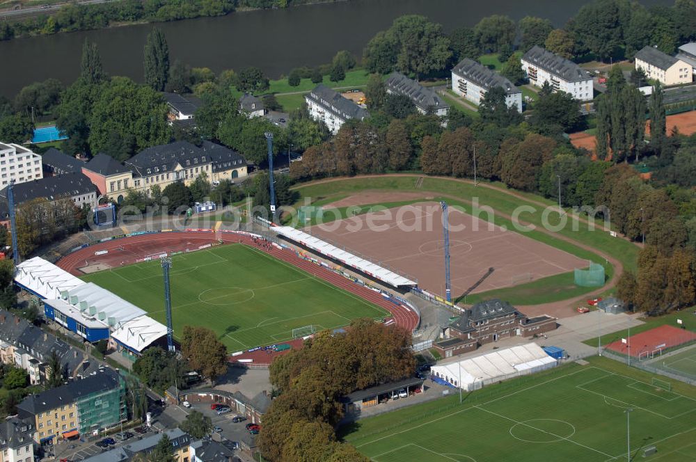 Aerial image Trier - Blick auf die Sportanlage am Moselstadion. Das Moselstadion wurde 1930 gegründet, damals trug die Sportanlage noch den Namen Auf der D´ham. Auf Grund des FDB-Halbfinalspiels wurde 1998 eine Flutlichtanlage errichtet. Genutzt wird das Stadion vom SV Eintracht Trier, der in der Saison 2003/ 04 in die zweite Bundesliga aufstieg. Seitdem wurden einige Besserungsarbeiten am Stadion vorgenommen. Die Haupttribüne wurde erweitert und ein Vereinslokal errichtet was den Anstieg der Besucherzahlen zur Folge hatte. Inzwischen ist der SV Eintracht Trier wieder abgestiegen und weitere Umbaumaßnamen wurden vorerst auf Eis gelegt. Momentan bietet das Stadion Platz für 10.254 Zuschauer wovon 8000 Stehplätze, davon wiederrum 2000 überdacht sind. 2000 weitere Sitzplätze finden sich auf der Tribüne. Kontakt: SV Eintracht Trier, Am Stadion 1 54292 Trier, Tel. +49(0)651 1467 10, Fax +49(0)651 1467 171, Email: info@sv-eintracht-trier05.de