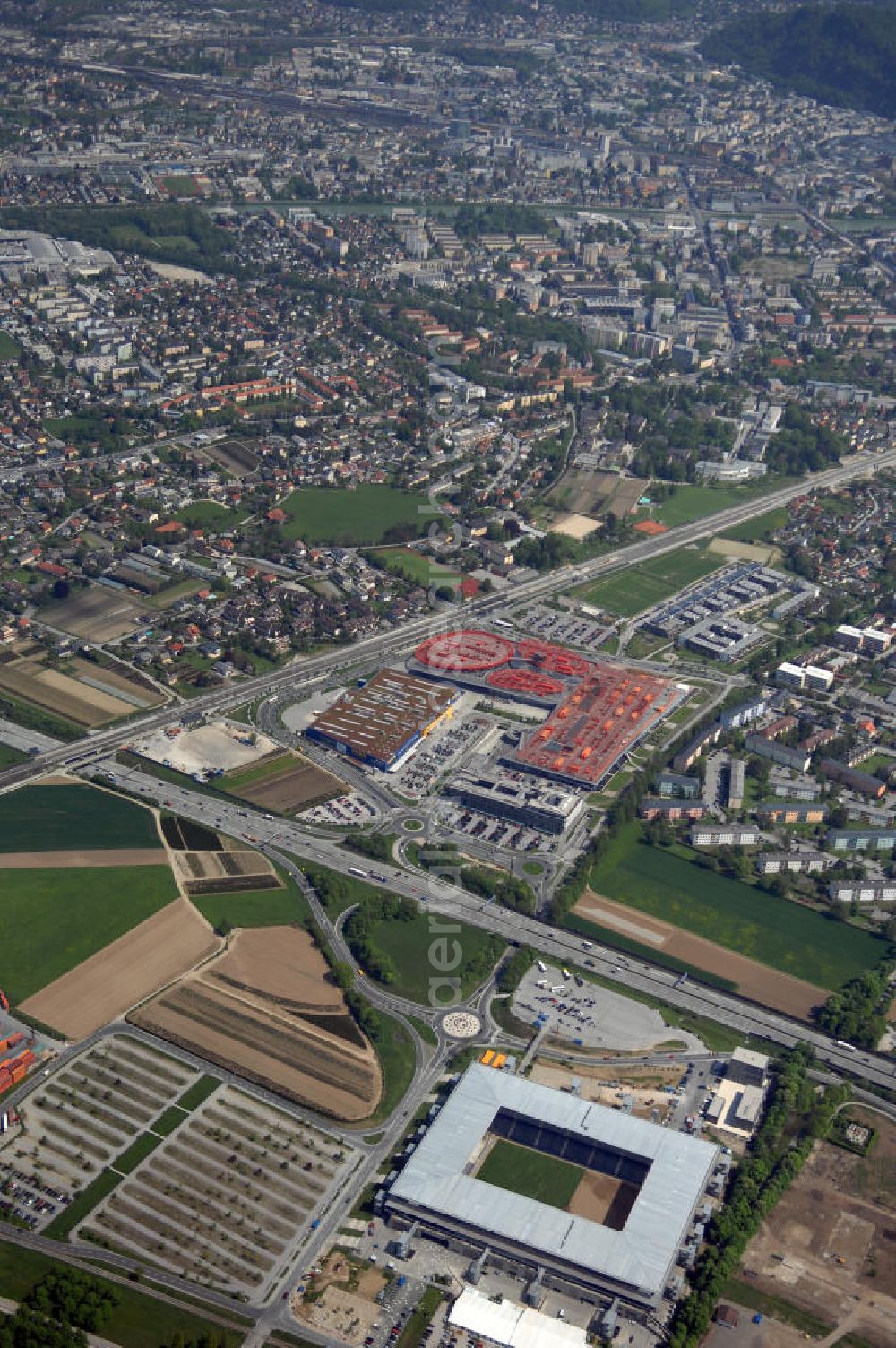 Salzburg from above - Das EM Stadion Wals-Siezenheim ist ein 28.900 Zuschauer fassendes Fußballstadion am Stadtrand von Salzburg in der Gemeinde Wals-Siezenheim, und Heimstätte des Fußballverein FC Red Bull Salzburg. Bei der Fußball Europameisterschaft 2008 wird es einer der vier österreichischen Austragungsorte sein. Aus diesem Grund trägt es, neben der Gemeindebezeichnung auch das Kürzel EM im offiziellen Stadionnamen. Eine eventuelle Umbenennung darf erst nach Beendigung der Europameisterschaft 2008 erfolgen. Das Stadion wurde im März 2003 fertiggestellt und gilt als Nachfolger des alten Lehener Stadions in dem von 1971 bis 2003 der Fußballverein Austria Salzburg beheimatet war.