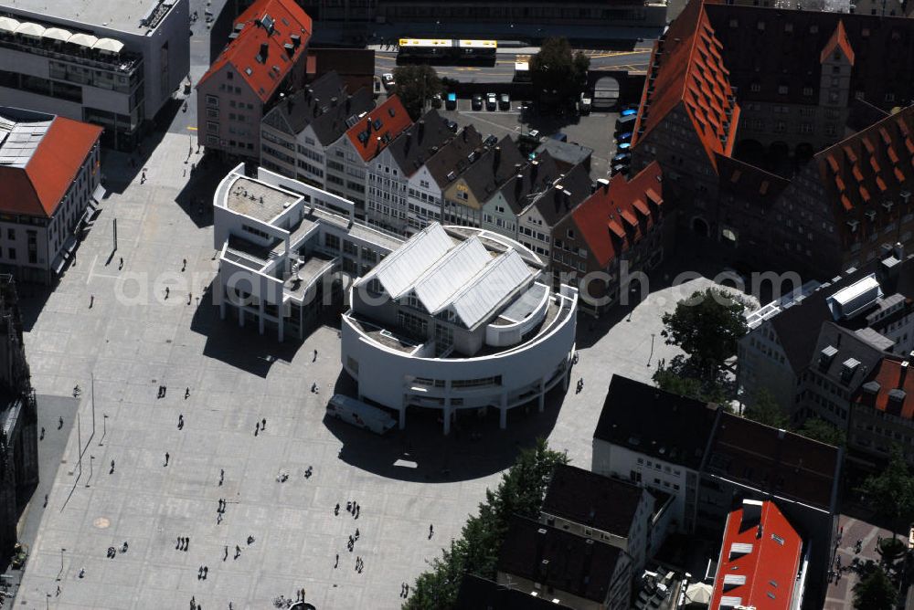 Aerial image Ulm - Blick auf das Stadthaus Ulm mit Café. Das Stadthaus befindet sich im Herzen Ulms auf dem Münsterplatz direkt vor dem höchsten Kirchturm der Welt, im weltberühmten Richard-Meier-Gebäude. Das Interieur des Cafés greift das Design der Klassisch-Modernen auf. Im November 1993 eröffnete Ulm einen neuen internationalen Markstein moderner Architektur: das Stadthaus. Der weiß verputzte und makellos geometrische, dreistöckige Pavillon verleiht dem Münsterplatz Klarheit und Schönheit, ohne dass dieser seinen reichen historischen Gehalt einbüßt. Das Stadthaus Ulm ist eines der wichtigsten europäischen Projekte Richard Meiers. Das Stadthaus produziert eigene Ausstellungen und kulturelle Veranstaltungen sowohl selbst als auch in Kooperation und versteht sich als Bürgerforum für Gastveranstaltungen. Es ist ein beliebter und vielgenutzter Treffpunkt. Je nach Anforderungsprofil einer Veranstaltung fungiert es als Ort für Ausstellungen, Konzerte, Diskussionsforen, Gesellschaftsabende oder als Kongresszentrum. Kontakt: Stadthaus, Münsterplatz 38, 89073 Ulm, Tel.: 0731 - 1617700, E-Mail: stadthaus@ulm.de