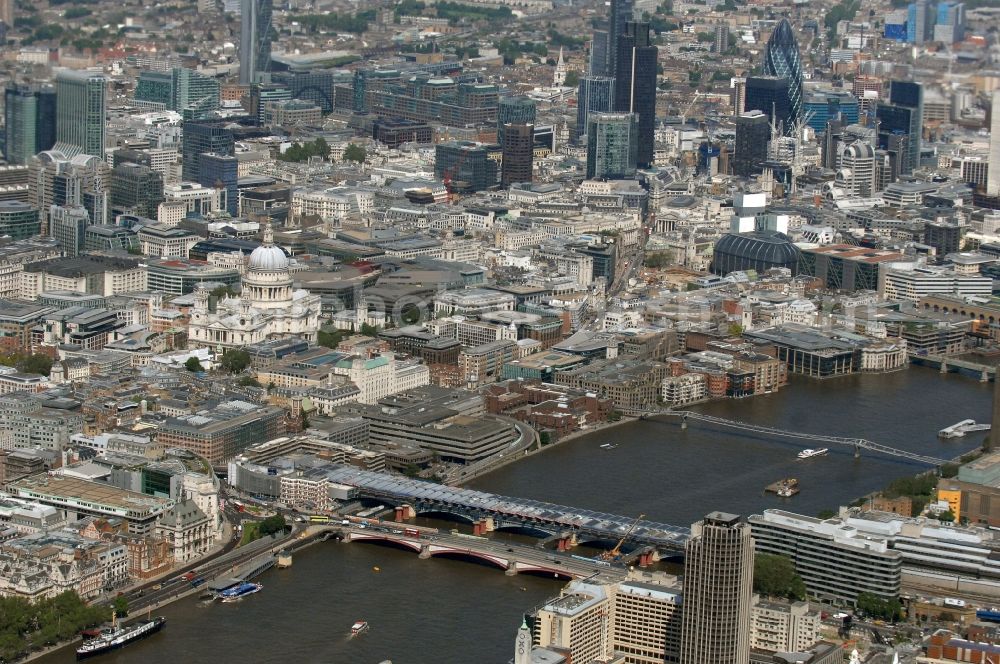 Aerial image Castle Baynard Ward - View of the road bridge Blackfriars Bridge and the covered railway bridge Blackfriars Railway Bridge in London. Blackfriars Bridge is a road bridge over the River Thames in London. It connects the City of London on the north side with the borough of Southwark in the London Borough of Southwark in the south. The bridge, which was build in Venetian-style, belongs to Bridge House Estates, a charitable organization of the Corporation of London and was designed by the architect and engineer Robert Mylne and opened in 1769. The associated railway bridge was designed by the architect John Cubitt and opened in 1864