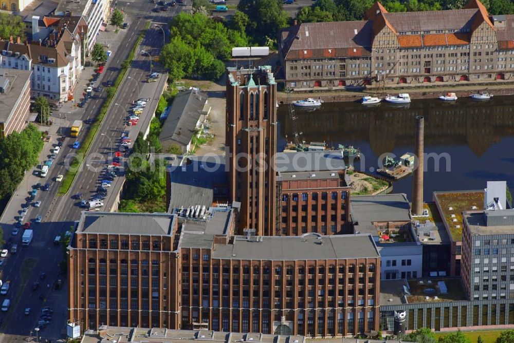 Berlin from above - Blick auf das Ullsteinhaus in Tempelhof.Das Ullsteinhaus im Süden Berlins im Ortsteil Tempelhof des Bezirks Tempelhof-Schöneberg und ist eine architektonische Landmarke dieses Bezirks.Es liegt direkt am Teltowkanal an der U-Bahnlinie U6 am U-Bahnhof Ullsteinstraße (Mariendorfer Damm 1–3).Das Ullsteinhaus wurde 1925–1927 vom Architekten Prof. Eugen Schmohl für den Ullstein-Verlag gebaut, der anschließend in dem Gebäude residierte. Auf den Druckmaschinen, die in im Ullsteinhaus standen, wurden die Drucksachen des Verlages hergestellt.Die „Ullstein-Eule“, die noch heute viele Buchumschläge des Ullstein-Verlags ziert, schmückt den Eingang des Ullsteinhauses am Mariendorfer Damm 1. Das Gebäude wurde in den Jahren 1993–1996 um einen Neubau ergänzt und hat eine Mietfläche von ca. 80.000 m². Der Altbau ist fünf- bis siebengeschossig. Der weithin sichtbare Uhrenturm hat zwölf Etagen. Der Neubau hat Bürotürme mit neun Etagen.