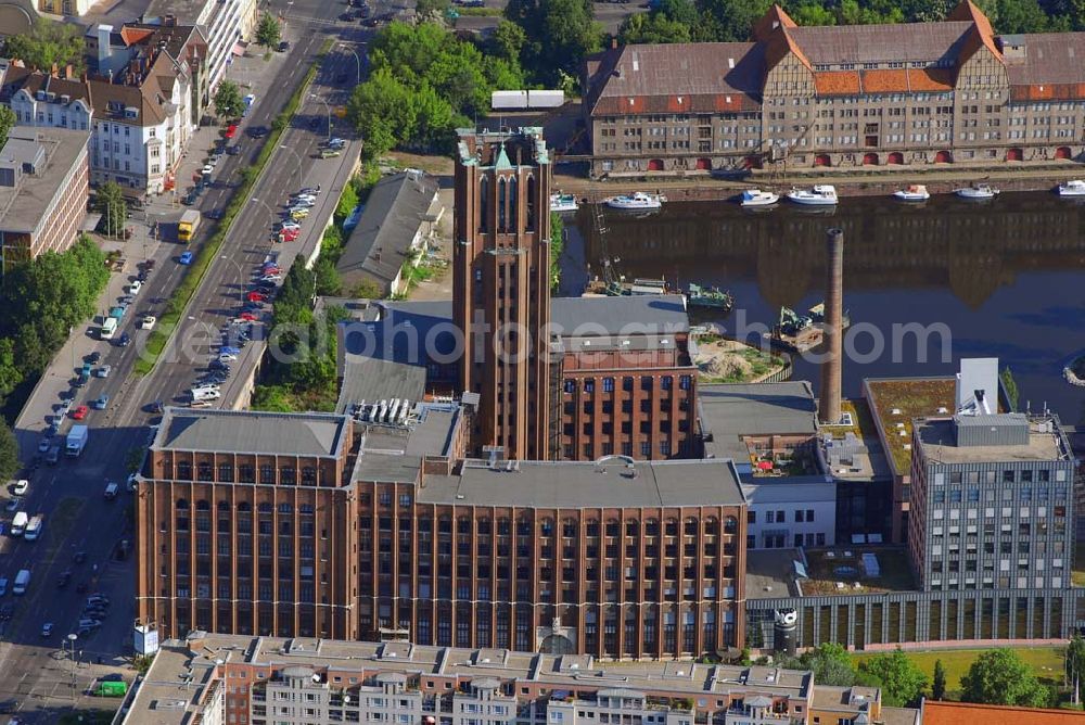 Berlin from the bird's eye view: Blick auf das Ullsteinhaus in Tempelhof.Das Ullsteinhaus im Süden Berlins im Ortsteil Tempelhof des Bezirks Tempelhof-Schöneberg und ist eine architektonische Landmarke dieses Bezirks.Es liegt direkt am Teltowkanal an der U-Bahnlinie U6 am U-Bahnhof Ullsteinstraße (Mariendorfer Damm 1–3).Das Ullsteinhaus wurde 1925–1927 vom Architekten Prof. Eugen Schmohl für den Ullstein-Verlag gebaut, der anschließend in dem Gebäude residierte. Auf den Druckmaschinen, die in im Ullsteinhaus standen, wurden die Drucksachen des Verlages hergestellt.Die „Ullstein-Eule“, die noch heute viele Buchumschläge des Ullstein-Verlags ziert, schmückt den Eingang des Ullsteinhauses am Mariendorfer Damm 1. Das Gebäude wurde in den Jahren 1993–1996 um einen Neubau ergänzt und hat eine Mietfläche von ca. 80.000 m². Der Altbau ist fünf- bis siebengeschossig. Der weithin sichtbare Uhrenturm hat zwölf Etagen. Der Neubau hat Bürotürme mit neun Etagen.