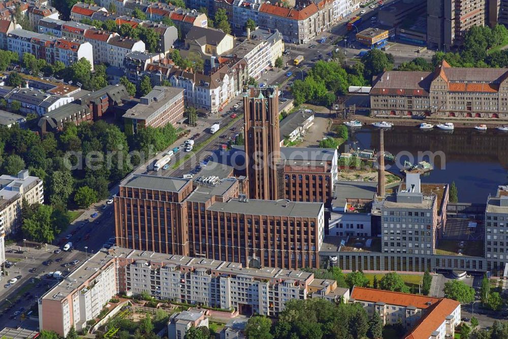 Aerial image Berlin - Blick auf das Ullsteinhaus in Tempelhof.Das Ullsteinhaus im Süden Berlins im Ortsteil Tempelhof des Bezirks Tempelhof-Schöneberg und ist eine architektonische Landmarke dieses Bezirks.Es liegt direkt am Teltowkanal an der U-Bahnlinie U6 am U-Bahnhof Ullsteinstraße (Mariendorfer Damm 1–3).Das Ullsteinhaus wurde 1925–1927 vom Architekten Prof. Eugen Schmohl für den Ullstein-Verlag gebaut, der anschließend in dem Gebäude residierte. Auf den Druckmaschinen, die in im Ullsteinhaus standen, wurden die Drucksachen des Verlages hergestellt.Die „Ullstein-Eule“, die noch heute viele Buchumschläge des Ullstein-Verlags ziert, schmückt den Eingang des Ullsteinhauses am Mariendorfer Damm 1. Das Gebäude wurde in den Jahren 1993–1996 um einen Neubau ergänzt und hat eine Mietfläche von ca. 80.000 m². Der Altbau ist fünf- bis siebengeschossig. Der weithin sichtbare Uhrenturm hat zwölf Etagen. Der Neubau hat Bürotürme mit neun Etagen.