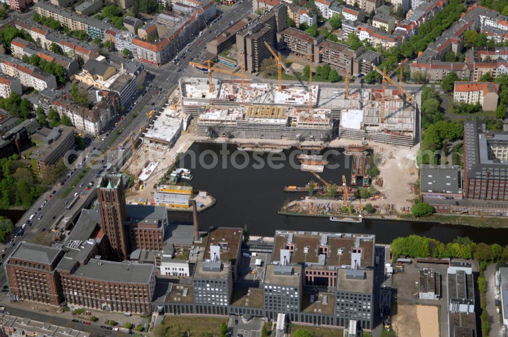 Aerial image Berlin - Blick auf die Baustelle vom Umbau Hafen Tempelhof am Ullsteinhaus. Der Tempelhofer Hafen entstand 1906 zusammen mit dem Teltowkanal. Zwei Jahre später kam der Speicher hinzu, eine der ersten Stahlbetonbauten in Deutschland. Im Krieg wurde das Gebäude schwer zerstört. Nach dem Wiederaufbau lagerte dort ein Teil der Lebensmittel-Reserve für West-Berlin. Bis zum Herbst 2008 sollen neben einer Einzelhandelsfläche von knapp 20 000 Quadratmetern und eine Fläche von etwa 10000 Quadratmeter für Unterhaltung, Grünflächen und Flanierwege entstehen. Hierfür wird der alte Speicher von einem Neubau flankiert. Etwa 70 Geschäfte haben in beiden Gebäuden Platz. Auf dem Dach des Neubaus entstehen 600 Parkplätze. Der Hafen selbst bleibt exklusiv Fußgängern und Freizeitkapitänen vorbehalten. Adresse: Ordensmeisterstraße, 12099 Berlin-Tempelhof; Kontakt Architekt: REM+tec Architekten, Gesellschaft für Projektentwicklung und Denkmalschutz mbH, Kurfürstenstraße 132, 10785 Berlin,Tel. 030 264767-70, Fax 030 264767-47, info@remtec.eu,