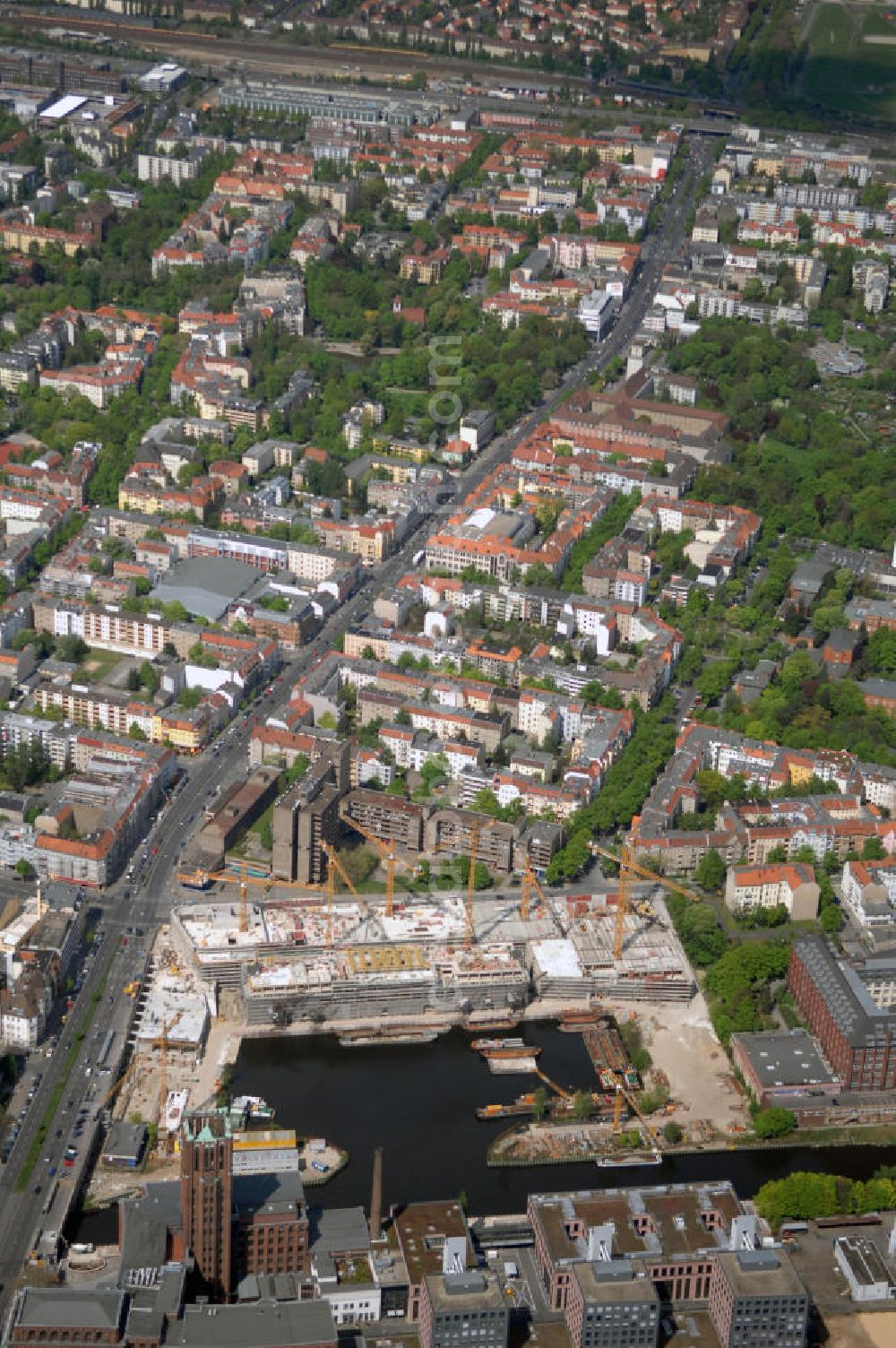 Berlin from the bird's eye view: Blick auf die Baustelle vom Umbau Hafen Tempelhof am Ullsteinhaus. Der Tempelhofer Hafen entstand 1906 zusammen mit dem Teltowkanal. Zwei Jahre später kam der Speicher hinzu, eine der ersten Stahlbetonbauten in Deutschland. Im Krieg wurde das Gebäude schwer zerstört. Nach dem Wiederaufbau lagerte dort ein Teil der Lebensmittel-Reserve für West-Berlin. Bis zum Herbst 2008 sollen neben einer Einzelhandelsfläche von knapp 20 000 Quadratmetern und eine Fläche von etwa 10000 Quadratmeter für Unterhaltung, Grünflächen und Flanierwege entstehen. Hierfür wird der alte Speicher von einem Neubau flankiert. Etwa 70 Geschäfte haben in beiden Gebäuden Platz. Auf dem Dach des Neubaus entstehen 600 Parkplätze. Der Hafen selbst bleibt exklusiv Fußgängern und Freizeitkapitänen vorbehalten. Adresse: Ordensmeisterstraße, 12099 Berlin-Tempelhof; Kontakt Architekt: REM+tec Architekten, Gesellschaft für Projektentwicklung und Denkmalschutz mbH, Kurfürstenstraße 132, 10785 Berlin,Tel. 030 264767-70, Fax 030 264767-47, info@remtec.eu,