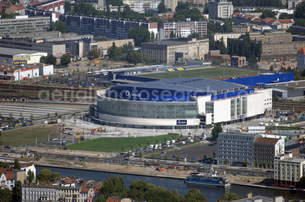 Berlin from above - Blick auf die o2 - Veranstaltungsarena in Berlin - Friedrichshain. Bei der O2 World handelt es sich um eine multifunktionale Veranstaltungshalle in Berlin zwischen Ostbahnhof und Warschauer Straße im Bezirk Friedrichshain-Kreuzberg. Die Grundsteinlegung erfolgte am 13. September 2006. In der Halle sollen Sportveranstaltungen wie Eishockey und Basketball, Sikveranstaltungen sowie viele weitere Events stattfinden. Bauherr und Investor ist die Anschutz Entertainment Group, die weltweit Arenen, Theater sowie verschiedene Tochterfirmen besitzt, betreibt und promotet. Die Firma O2 Germany hat die Namensrechte an der Arena in Berlin erworben.Mit bis zu 17.000 Sitz- und Stehplätzen, 59 Entertainment-Suiten soll die O2 World die größte Veranstaltungshalle Berlins werden und eine Vielzahl von Events ermöglichen.Für den Profi-Eishockeyclub Eisbären Berlin soll die Arena die neue sportliche Heimat werden.Anschrift: Anschutz Entertainment Group Q 207 Friedrichrichstraße 76,10117 Berlin,Tel.: +49 (0)30-20 60 70 80 Fax: +49 (0)30-20 60 70 81 11, presse@o2-world.de