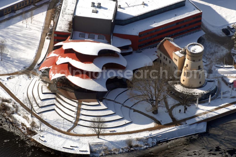 Aerial image POTSDAM - Blick auf das verschneite Hans Otto Theater, dem Brandenburgischen Landestheaters in Potsdam. Seit dem 22. September 2006 spielt das Ensemble in dem neuen Potsdamer Theaterhaus in der Schiffbauergasse am Ufer des Tiefen Sees.Der Architekt Gottfried Böhm entwarf ein fünfgeschossiges Theatergebäude mit schalenförmigen Dächern nach dem Vorbild des Sydney Opera House, die wie drei große Hutkrempen weit in das Ufer der Havel hineinzuragen scheinen. Ein alter Gasometer, der von einer Gasanstalt übrig geblieben ist, ist in die Architektur integriert und dient jetzt als Hof mit Wirtschaftsräumen. Beton und Glas sind die Materialien, die das Bauwerk charakterisieren.Das Obere Foyer und der Bühnensaal haben jeweils eine große Glasfensterfront, die der Bühne kann komplett abgedunkelt werden. Im Großen Saal ist für max. 480 Zuschauer Platz. Unter den Zuschauerreihen sind 50 Hubpodien angeordnet, mit denen das Auditorium gesenkt und gehoben werden kann. Die Hinterbühnen lassen sich weit öffnen, so dass man bis hinaus in den Innenraum des Gasometers schauen kann. BATEG Ingenieurbau GmbH - http://