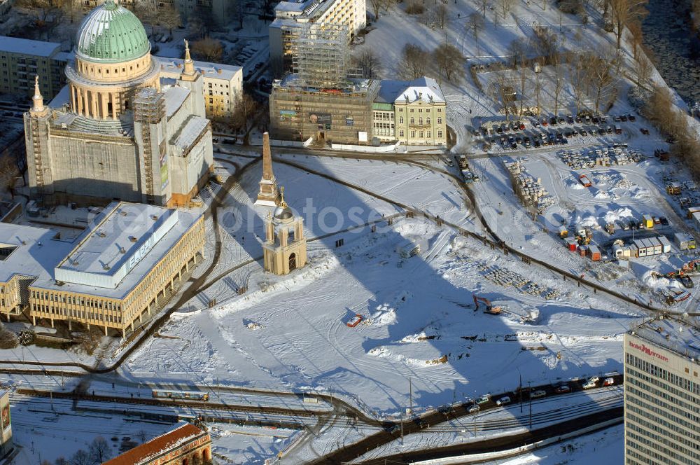 POTSDAM from the bird's eye view: Blick auf das verschneite Stadtzentrum am Alten Markt von Potsdam mit dem Hotel Mercure (vorn r.), der eingerüsteten evangelischen Kirche St. Nikolai (l.) und dem ebenfalls eingerüsteten Alten Rathaus (daneben r.), aufgenommen am 05.01.2009. In der Bildmitte die Baustelle für den künftigen Brandenburger Landtag auf dem Areal des früheren Stadtschlosses.