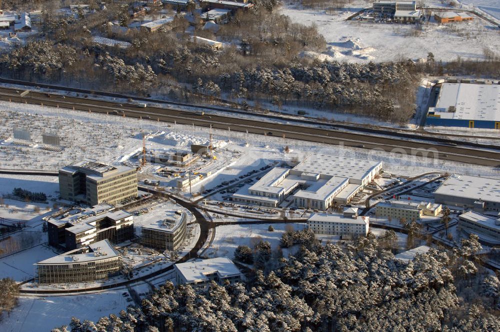 Aerial photograph Dreilinden - Blick auf den verschneiten Erweiterungsbaustelle Europapark Dreilinden bei der Waldsiedlung Dreilinden nahe der brandenburgischen Gemeinde Kleinmachnow (Landkreis Potsdam-Mittelmark) südwestlich von Berlin. Dreilinden ist der Name eines Forstes und einer Kolonie und war besonders bekannt als Bezeichnung für die frühere Grenzübergangsstelle Drewitz. Der ab 1990 errichtete Europapark ist ein Gewerbepark auf dem ehemaligen Gelände der wichtigsten Transitstrecke nach Westen und Süden (Checkpoint Bravo).