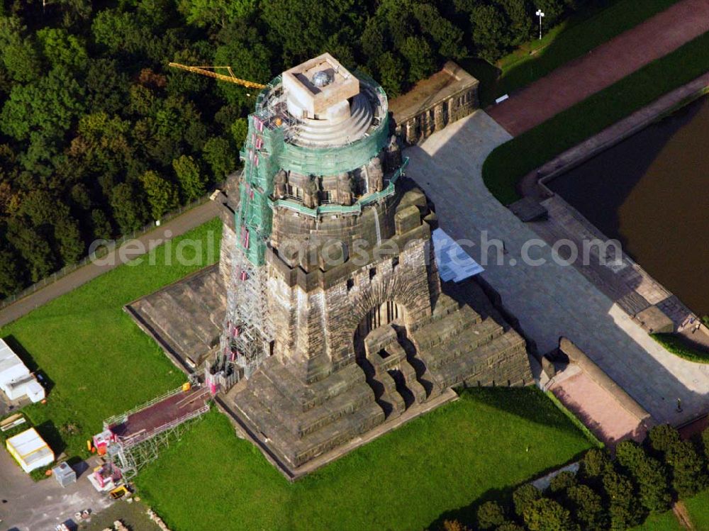 Aerial image Leipzig - 27.08.2005 Leipzig; Für die Sanierung des Völkerschlachtdenkmales wurde in den letzten Jahren sehr viel getan. So konnten die Kriegsschäden in der Ruhmeshalles beseitigt werden. Es erfolgten notwendige Erschließungsarbeiten zur Durchführung der Baumaßnahmen. Der Zugang über das Plateau unter dem Michael-Relief wurde geschaffen, Grundleitungen verlegt, Stahlbetonarbeiten an Decke und Wänden ausgeführt.Das Völkerschlachtdenkmal Leipzig erinnert an die erste große Massenschlacht der Menschheitsgeschichte. Über eine halbe Million Soldaten aus fast ganz Europa stan­den sich im Oktober 1813 auf den Schlachtfeldern um Leipzig gegenüber. Mehr als 120 000 Menschen haben während der blutigen Kämpfe oder anschließend durch Hunger und Seuchen ihr Leben verloren.