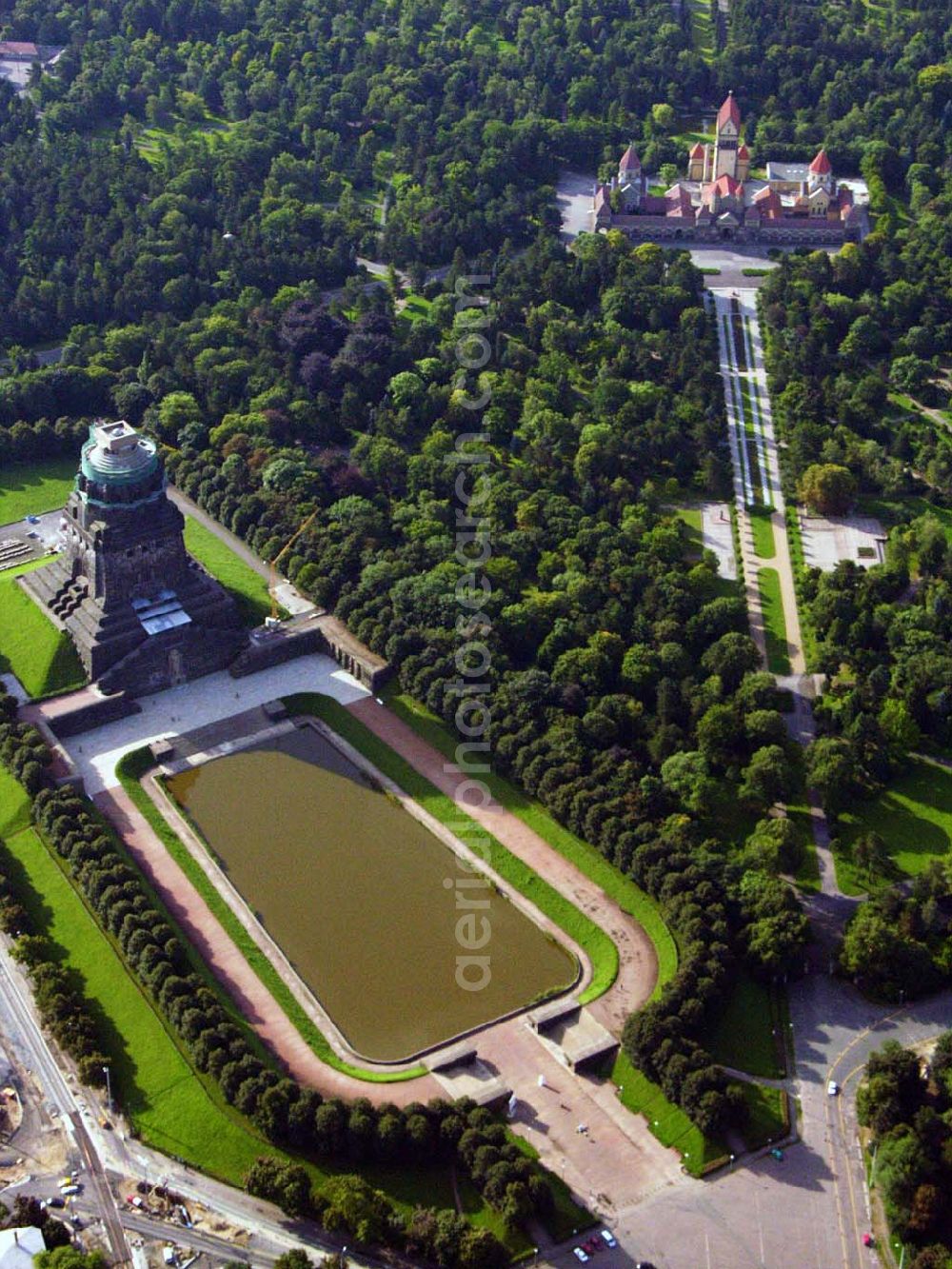 Aerial image Leipzig - 27.08.2005 Leipzig; Für die Sanierung des Völkerschlachtdenkmales wurde in den letzten Jahren sehr viel getan. So konnten die Kriegsschäden in der Ruhmeshalles beseitigt werden. Es erfolgten notwendige Erschließungsarbeiten zur Durchführung der Baumaßnahmen. Der Zugang über das Plateau unter dem Michael-Relief wurde geschaffen, Grundleitungen verlegt, Stahlbetonarbeiten an Decke und Wänden ausgeführt.Das Völkerschlachtdenkmal Leipzig erinnert an die erste große Massenschlacht der Menschheitsgeschichte. Über eine halbe Million Soldaten aus fast ganz Europa stan­den sich im Oktober 1813 auf den Schlachtfeldern um Leipzig gegenüber. Mehr als 120 000 Menschen haben während der blutigen Kämpfe oder anschließend durch Hunger und Seuchen ihr Leben verloren.