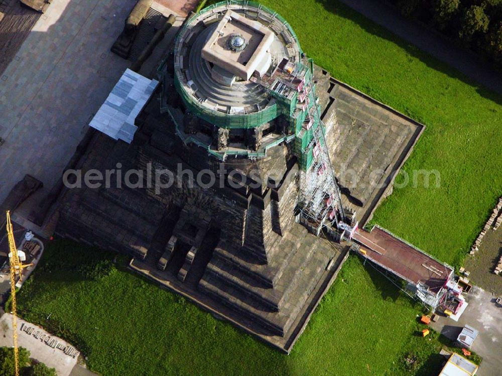 Aerial image Leipzig - 27.08.2005 Leipzig; Für die Sanierung des Völkerschlachtdenkmales wurde in den letzten Jahren sehr viel getan. So konnten die Kriegsschäden in der Ruhmeshalles beseitigt werden. Es erfolgten notwendige Erschließungsarbeiten zur Durchführung der Baumaßnahmen. Der Zugang über das Plateau unter dem Michael-Relief wurde geschaffen, Grundleitungen verlegt, Stahlbetonarbeiten an Decke und Wänden ausgeführt.Das Völkerschlachtdenkmal Leipzig erinnert an die erste große Massenschlacht der Menschheitsgeschichte. Über eine halbe Million Soldaten aus fast ganz Europa stan­den sich im Oktober 1813 auf den Schlachtfeldern um Leipzig gegenüber. Mehr als 120 000 Menschen haben während der blutigen Kämpfe oder anschließend durch Hunger und Seuchen ihr Leben verloren.