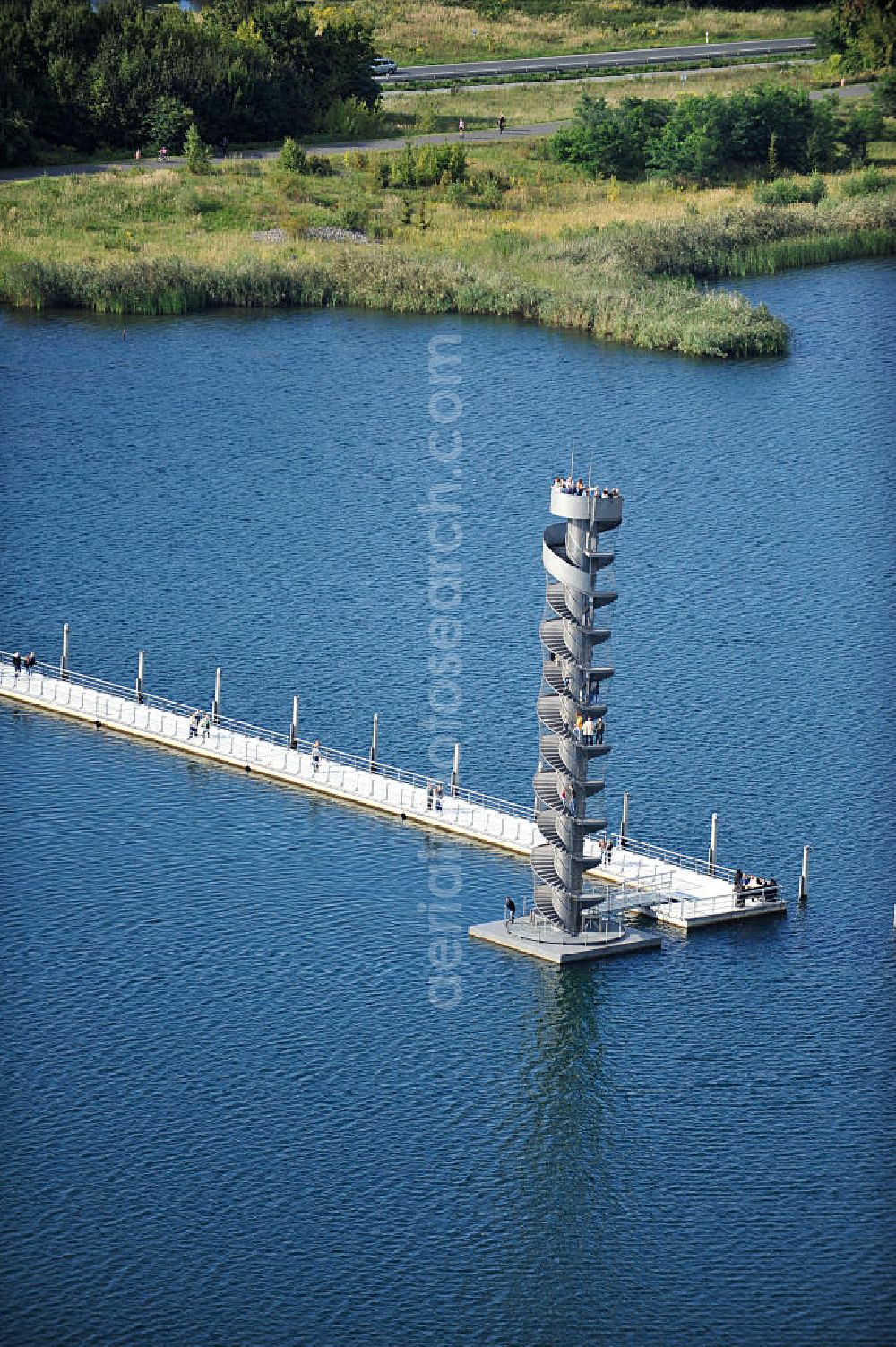 Aerial photograph Bitterfeld - Blick auf das Wahrzeichen der Goitzsche, der Pegelturm mit Seebrücke im Goitzsche-See bei Bitterfeld, eine in Europa einmalige Seenlandschaft. Aus den Braunkohletagebauen Holzweißig West und Ost ist eine künstlich modellierte Kulturlandschaft entstanden.Insbesondere zur Expo 2000 entstandene Projekte haben die Goitzsche um eine kulturelle Dimension erweitert. Die Rückgewinnung einer Landschaft durch die Region und ihre Menschen sind die Sinn stiftenden Elemente der Bergbaufolge- und Kulturlandschaft Goitzsche. Gemeinsam gestalten die Ufergemeinden der Goitzsche ihre Ufer, entwickeln Flächen im Umland, verknüpfen Kunst, neue Architektur mit einprägsamer Landschaftsgestaltung. Goitzsche landmark, the tower level with the pier Goitzsche lake near Bitterfeld.