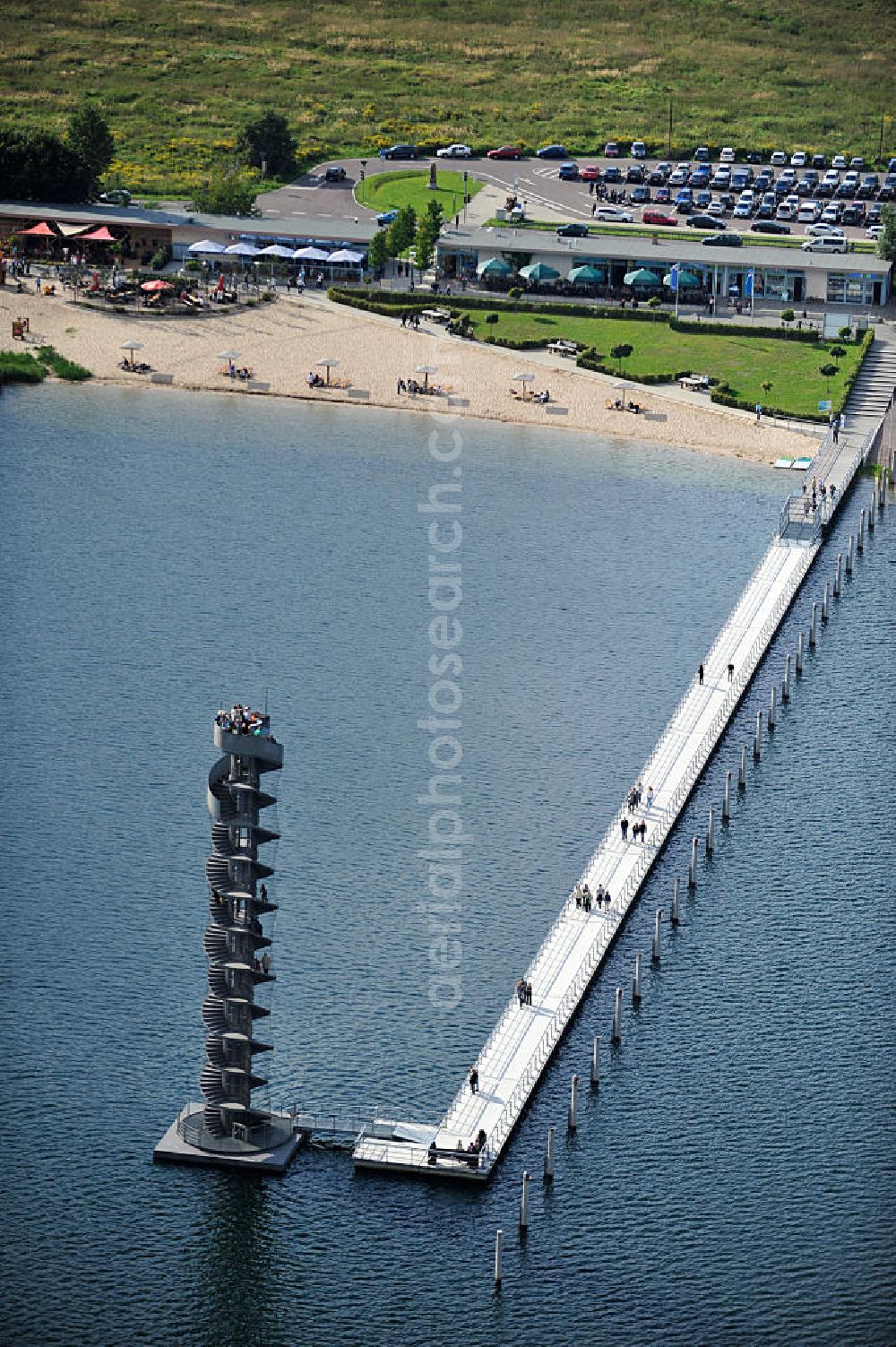 Aerial photograph Bitterfeld - Blick auf das Wahrzeichen der Goitzsche, der Pegelturm mit Seebrücke im Goitzsche-See bei Bitterfeld, eine in Europa einmalige Seenlandschaft. Aus den Braunkohletagebauen Holzweißig West und Ost ist eine künstlich modellierte Kulturlandschaft entstanden.Insbesondere zur Expo 2000 entstandene Projekte haben die Goitzsche um eine kulturelle Dimension erweitert. Die Rückgewinnung einer Landschaft durch die Region und ihre Menschen sind die Sinn stiftenden Elemente der Bergbaufolge- und Kulturlandschaft Goitzsche. Gemeinsam gestalten die Ufergemeinden der Goitzsche ihre Ufer, entwickeln Flächen im Umland, verknüpfen Kunst, neue Architektur mit einprägsamer Landschaftsgestaltung. Goitzsche landmark, the tower level with the pier Goitzsche lake near Bitterfeld.