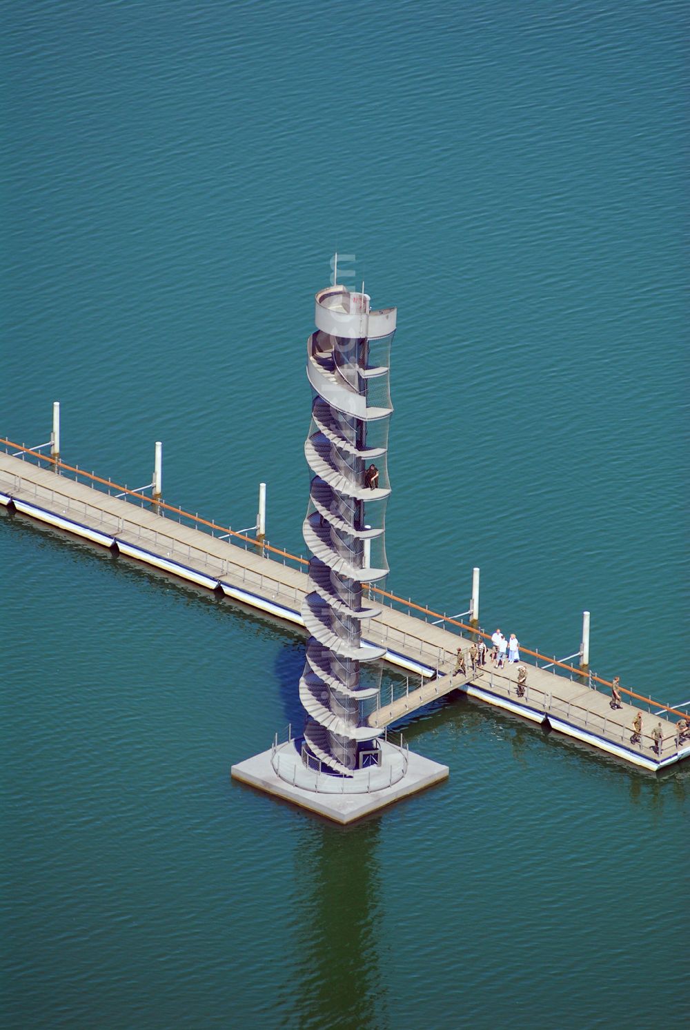 Aerial photograph Bitterfeld - Blick auf das Wahrzeichen der Goitzsche, der Pegelturm mit Seebrücke im Goitzsche-See bei Bitterfeld, eine in Europa einmalige Seenlandschaft. Aus den Braunkohletagebauen Holzweißig West und Ost ist eine künstlich modellierte Kulturlandschaft entstanden.Insbesondere zur Expo 2000 entstandene Projekte haben die Goitzsche um eine kulturelle Dimension erweitert. Die Rückgewinnung einer Landschaft durch die Region und ihre Menschen sind die Sinn stiftenden Elemente der Bergbaufolge- und Kulturlandschaft Goitzsche. Gemeinsam gestalten die Ufergemeinden der Goitzsche ihre Ufer, entwickeln Flächen im Umland, verknüpfen Kunst, neue Architektur mit einprägsamer Landschaftsgestaltung.