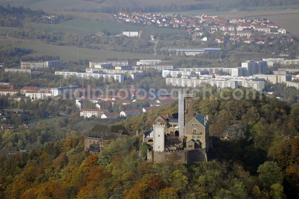 Aerial photograph EISENACH - Weithin sichtbares Wahrzeichen und Touristenmagnet ist die Eisenacher Wartburg-Stiftung Eisenach. Sie wurde um 1067 von Ludwig dem Springer gegründet und gehört seit 1999 zum Weltkulturerbe. Einem humorvollen Mythos nach erwarb das Schloss seinen Namen, als sein Begründer den Berg, auf dem das Schloss heute sitzt, zum ersten Mal sah. Vom Ort entzückt schrie er angeblich auf: „Wart’, Berg – du sollst mir eine Burg tragen!“ Die tatsächliche Bedeutung des Namens ist Wach-, Wächterburg. Die heutige Wartburg-Stiftung Eisenach ist größtenteils im 19. Jahrhundert unter Einbeziehung weniger erhaltener Teile neu gebaut worden. Das heutige Erscheinungsbild der Wartburg-Stiftung Eisenach und ihres Landschaftsparks geht auf den Großherzog Carl Alexan der von Sachsen-Weimar-Eisenach zurück.Wie kaum eine an dere Burg Deutschlands ist die Wartburg-Stiftung Eisenach mit der Geschichte Deutschlands verbunden. 1211 bis 1227 lebte die später heilig gesprochene Elisabeth von Thüringen auf der Burg. 1521/22 hielt sich der Reformator Martin Luther als „Junker Jörg“ hier versteckt und übersetzte während dieser Zeit das Neue Testament der Bibel in nur 11 Wochen ins Deutsche. Johann Wolfgang von Goethe weilte mehrfach hier, erstmals im Jahr 1777. Am 18. Oktober 1817 fand auf der Burg mit dem ersten Wartburg-Stiftung Eisenachfest das Burschenschaftstreffen der deutschen Studenten statt. Das zweite Wartburg-Stiftung Eisenachfest wurde im Revolutionsjahr 1848 veranstaltet.