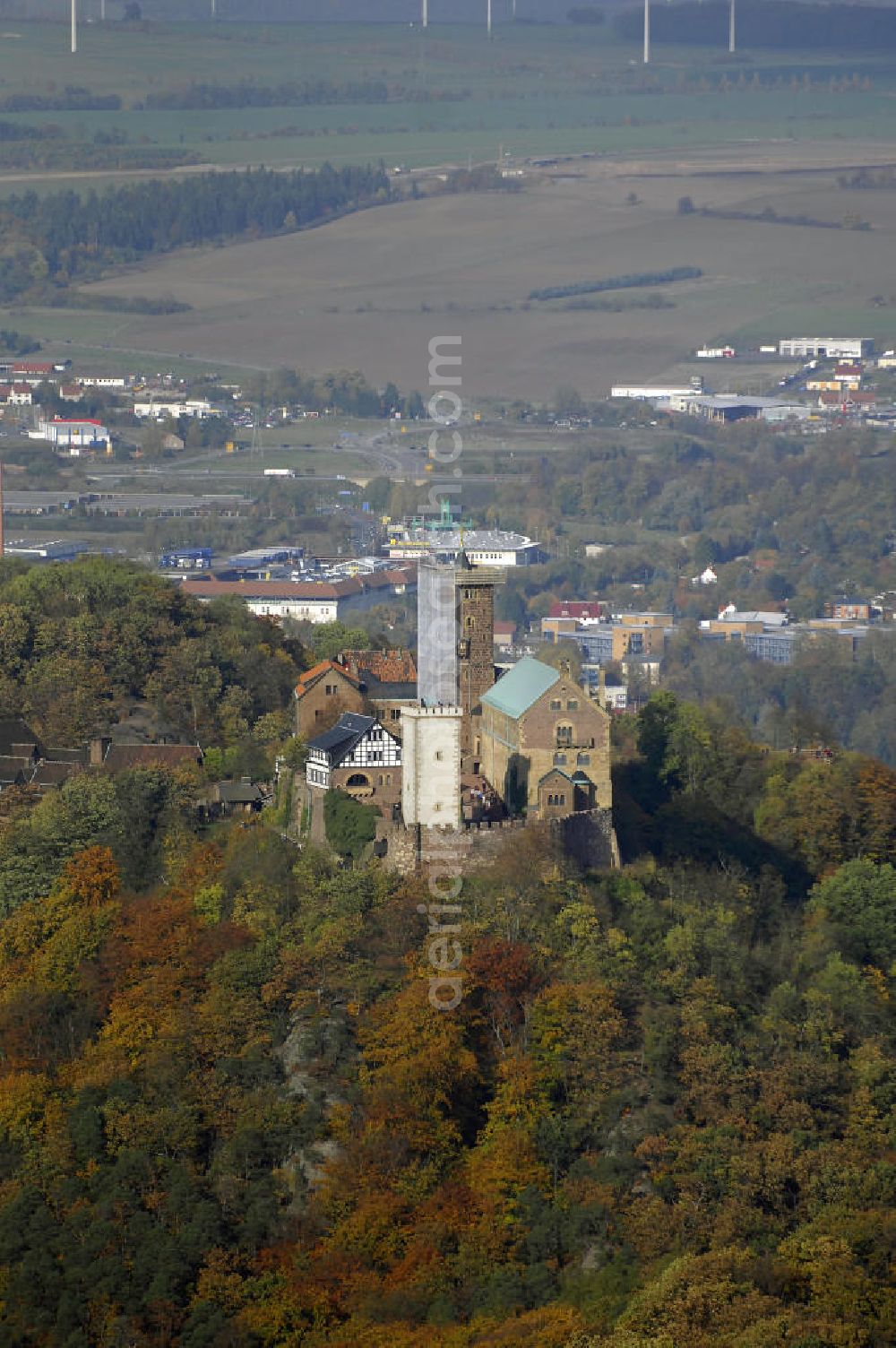 EISENACH from the bird's eye view: Weithin sichtbares Wahrzeichen und Touristenmagnet ist die Eisenacher Wartburg-Stiftung Eisenach. Sie wurde um 1067 von Ludwig dem Springer gegründet und gehört seit 1999 zum Weltkulturerbe. Einem humorvollen Mythos nach erwarb das Schloss seinen Namen, als sein Begründer den Berg, auf dem das Schloss heute sitzt, zum ersten Mal sah. Vom Ort entzückt schrie er angeblich auf: „Wart’, Berg – du sollst mir eine Burg tragen!“ Die tatsächliche Bedeutung des Namens ist Wach-, Wächterburg. Die heutige Wartburg-Stiftung Eisenach ist größtenteils im 19. Jahrhundert unter Einbeziehung weniger erhaltener Teile neu gebaut worden. Das heutige Erscheinungsbild der Wartburg-Stiftung Eisenach und ihres Landschaftsparks geht auf den Großherzog Carl Alexan der von Sachsen-Weimar-Eisenach zurück.Wie kaum eine an dere Burg Deutschlands ist die Wartburg-Stiftung Eisenach mit der Geschichte Deutschlands verbunden. 1211 bis 1227 lebte die später heilig gesprochene Elisabeth von Thüringen auf der Burg. 1521/22 hielt sich der Reformator Martin Luther als „Junker Jörg“ hier versteckt und übersetzte während dieser Zeit das Neue Testament der Bibel in nur 11 Wochen ins Deutsche. Johann Wolfgang von Goethe weilte mehrfach hier, erstmals im Jahr 1777. Am 18. Oktober 1817 fand auf der Burg mit dem ersten Wartburg-Stiftung Eisenachfest das Burschenschaftstreffen der deutschen Studenten statt. Das zweite Wartburg-Stiftung Eisenachfest wurde im Revolutionsjahr 1848 veranstaltet.