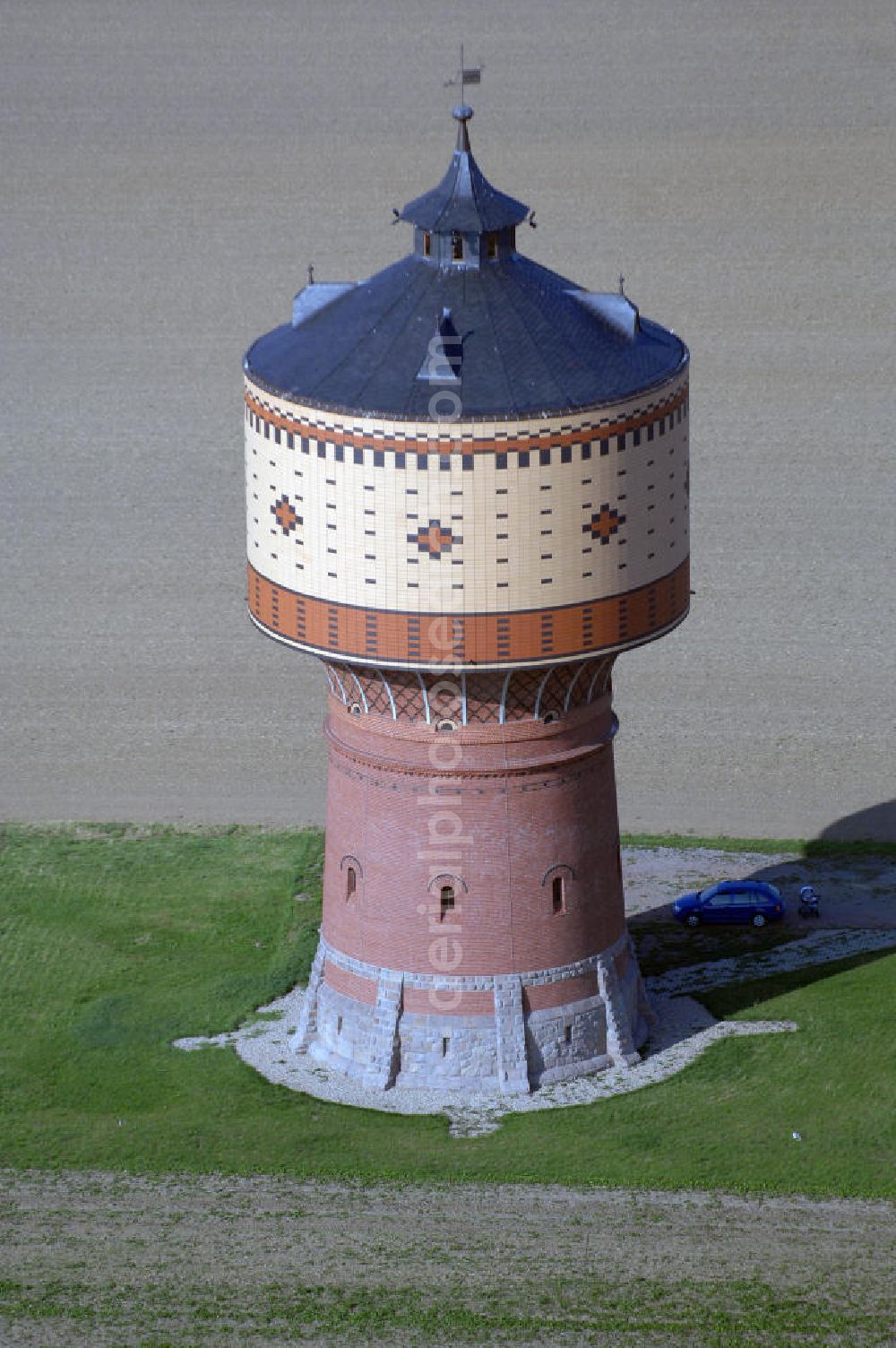 Mittweida from above - Blick auf den Wasserturm bei Mittweida. Der 1898 fertiggestellte Turm dient der Stadt Mittweida als Tagesausgleichsbehälter um den Bedarf der unteren Wasserdruckzone zu sichern. Er ist aber gleichzeitig auch Feuerlöschwasserreserve. 1970/ 71 wurde eine Teilsanierung am Turm durchgeführt, da eine statische Überlastung im Fassadenbereich befürchtet wurde. In den Jahren 2005 und 2006 erfolgte dann eine erneute Sanierung. Es wurde unter an derem der Wasserbehälter saniert, eine Behälterabdeckung mit Be- und Entlüftung nach außen eingebaut, eine Reinigungstechnologie für die Wasserkammer erstellt, die Rohrleitungen wurden neu ausgerüstet, Fassade und Dach wurden erneuert und man errichtete eine Zuführungsleitung zum Wasserturm. Kontakt: Stadtverwaltung Mittweida, Markt 32, Rathaus Haus 1 09648 Mittweida, Tel. +49(0)3727 976 0, Fax +49(0)3727 976 180, Email: stadtverwaltung@mittweida.de