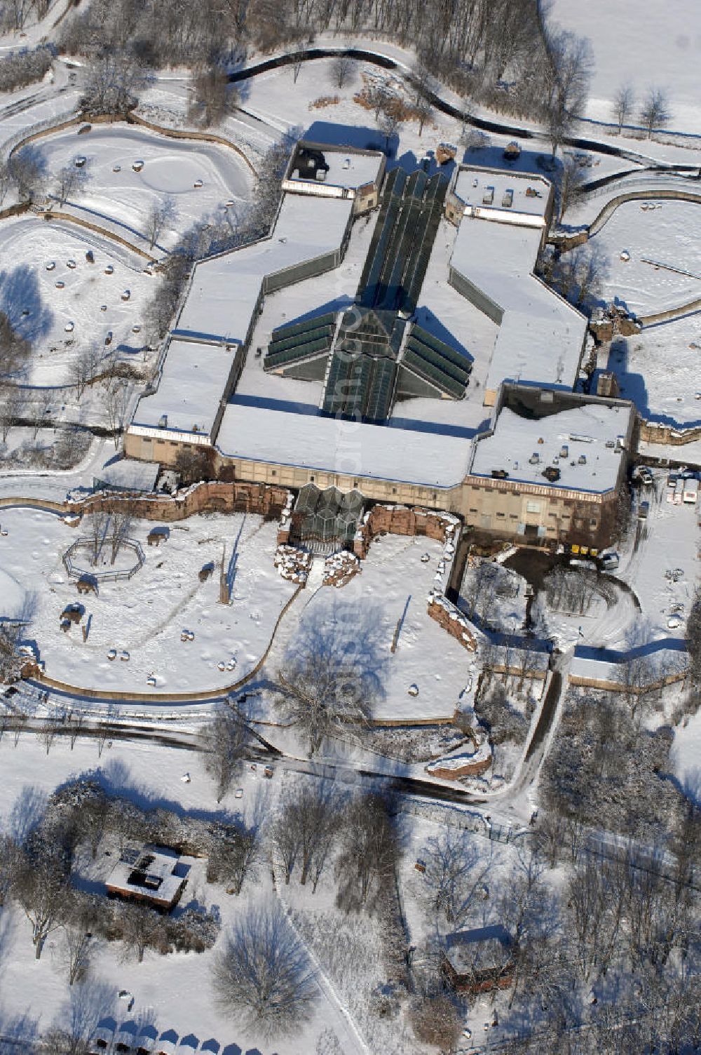 Berlin from above - Blick auf den winterlich verschneite Elefantenhaus im Berliner Tierpark in Friedrichsfelde. Der Tierpark Berlin-Friedrichsfelde im Bezirk Lichtenberg ist einer der beiden Zoologischen Gärten in Berlin und mit 160 Hektar Fläche der größte Landschaftstiergarten in Europa. Mehr als 7.500 Tiere in fast 1.000 Arten präsentieren sich in großzügigen Gehegen. In den Gesamtkontext passende Gartenanlagen verstärken den Eindruck eines Parks. In den letzten Jahren ist der Tierpark über Berlin hinaus insbesondere durch seine Zucht von Afrikanischen Elefanten bekannt geworden.