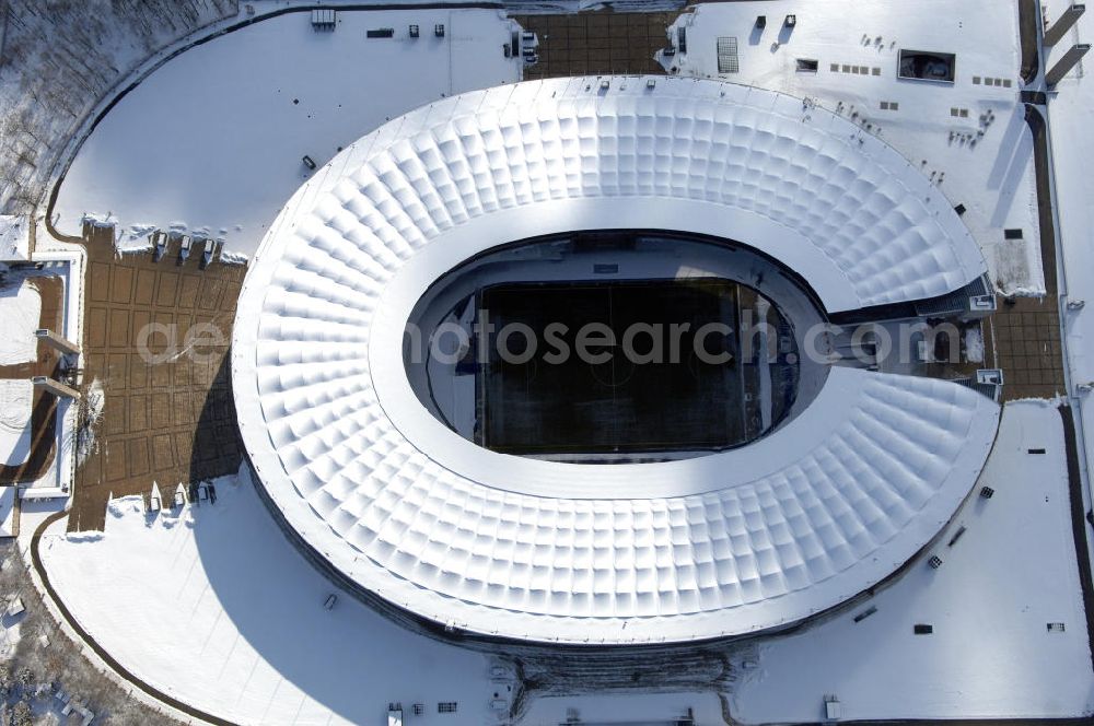 Aerial image Berlin - Blick auf das winterlich verschneite Olypiastadion Berlin. Das Olympiastadion wurde von 1934 bis 1936 anlässlich der Olympischen Sommerspiele 1936 mit einem Fassungsvermögen von 100.000 Zuschauern nach Plänen des Architekten Werner March erbaut.Seine Heimspiele trägt der Hauptnutzer, die Fußball-Bundesliga-Mannschaft von Hertha BSC, im Olympiastadion aus, und die jährlichen Endspiele um den DFB-Pokal der Damen und Herren finden hier seit 1985 statt. Das American-Football-Team von Berlin Thunder bestritt hier seine Heimspiele in der NFL Europe bis Juni 2007. Zusätzlich werden Leichtathletik-Wettkämpfe, wie das jährliche ISTAF, ausgetragen. Am 4. Dezember 2004 wurde Berlin zum Austragungsort der Leichtathletik-Weltmeisterschaft 2009 erkoren, die im Olympiastadion ausgetragen werden wird. Gelegentlich wird das Stadion auch für Großveranstaltungen ohne sportlichen Charakter, wie etwa Kirchentage oder Konzerte, genutzt. Das Olympiastadion besitzt die größte Stadionkapelle der Welt. http://