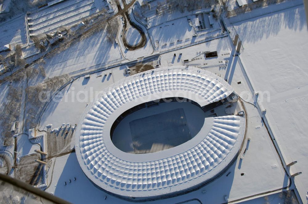 Berlin from above - Blick auf das winterlich verschneite Olypiastadion Berlin. Das Olympiastadion wurde von 1934 bis 1936 anlässlich der Olympischen Sommerspiele 1936 mit einem Fassungsvermögen von 100.000 Zuschauern nach Plänen des Architekten Werner March erbaut.Seine Heimspiele trägt der Hauptnutzer, die Fußball-Bundesliga-Mannschaft von Hertha BSC, im Olympiastadion aus, und die jährlichen Endspiele um den DFB-Pokal der Damen und Herren finden hier seit 1985 statt. Das American-Football-Team von Berlin Thunder bestritt hier seine Heimspiele in der NFL Europe bis Juni 2007. Zusätzlich werden Leichtathletik-Wettkämpfe, wie das jährliche ISTAF, ausgetragen. Am 4. Dezember 2004 wurde Berlin zum Austragungsort der Leichtathletik-Weltmeisterschaft 2009 erkoren, die im Olympiastadion ausgetragen werden wird. Gelegentlich wird das Stadion auch für Großveranstaltungen ohne sportlichen Charakter, wie etwa Kirchentage oder Konzerte, genutzt. Das Olympiastadion besitzt die größte Stadionkapelle der Welt. http://