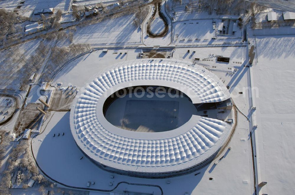 Berlin from the bird's eye view: Blick auf das winterlich verschneite Olypiastadion Berlin. Das Olympiastadion wurde von 1934 bis 1936 anlässlich der Olympischen Sommerspiele 1936 mit einem Fassungsvermögen von 100.000 Zuschauern nach Plänen des Architekten Werner March erbaut.Seine Heimspiele trägt der Hauptnutzer, die Fußball-Bundesliga-Mannschaft von Hertha BSC, im Olympiastadion aus, und die jährlichen Endspiele um den DFB-Pokal der Damen und Herren finden hier seit 1985 statt. Das American-Football-Team von Berlin Thunder bestritt hier seine Heimspiele in der NFL Europe bis Juni 2007. Zusätzlich werden Leichtathletik-Wettkämpfe, wie das jährliche ISTAF, ausgetragen. Am 4. Dezember 2004 wurde Berlin zum Austragungsort der Leichtathletik-Weltmeisterschaft 2009 erkoren, die im Olympiastadion ausgetragen werden wird. Gelegentlich wird das Stadion auch für Großveranstaltungen ohne sportlichen Charakter, wie etwa Kirchentage oder Konzerte, genutzt. Das Olympiastadion besitzt die größte Stadionkapelle der Welt. http://