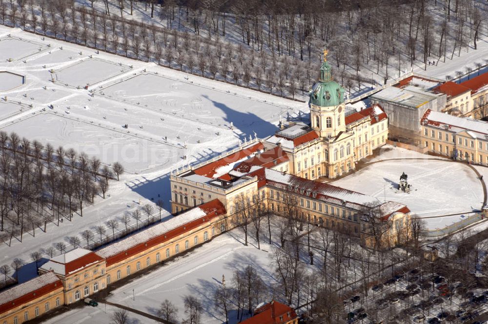 Berlin from above - Blick auf den winterlich verschneite Schloß Charlottenburg. Die spätere Schlossinsel Köpenick wurde schon zu urgeschichtlicher Zeit besiedelt und ist neben Spandau und Cölln eine der frühesten Siedlungsgebiete des heutigen Berlins. Hier fanden sich später slawische Burgwälle, eine slawische Burg entstand im 8. oder 9. Jahrhundert. Mehrere Nachfolgebauten folgten, darunter auch eine spätmittelalterliche Kastellburg. Der Slawenfürst Jaxa von Köpenick regierte hier im 12. Jahrhundert.Für Kurprinz Friedrich (später Kurfürst Friedrich III. von Brandenburg, dann auch König Friedrich I. in Preußen) wurde das Schloss ab 1677 erweitert. Als Architekt war hierbei Rutger van Langervelt, ein geborener Holländer aus Nimwegen, verantwortlich. Der nördliche Pavillon entstand in den Jahren 1679–1682. Der Architekt Johann Arnold Nering folgte van Langervelt 1684 beim Schlossbau und ließ den Wirtschaftsflügel mit der reformierten Schlosskirche (eingeweiht am 6. Januar 1685) und zuvor bereits das Hoftor (1682) entstehen. Friedrich bewohnte das Schloss später mit seiner Gemahlin Elisabeth Henriette von Hessen-Kassel, die den Anstoß zum Bau der Kirche gegeben haben soll.