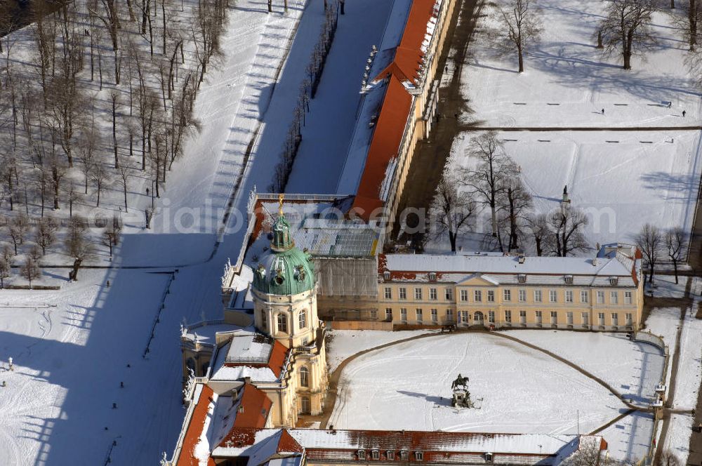 Berlin from above - Blick auf den winterlich verschneite Schloß Charlottenburg. Die spätere Schlossinsel Köpenick wurde schon zu urgeschichtlicher Zeit besiedelt und ist neben Spandau und Cölln eine der frühesten Siedlungsgebiete des heutigen Berlins. Hier fanden sich später slawische Burgwälle, eine slawische Burg entstand im 8. oder 9. Jahrhundert. Mehrere Nachfolgebauten folgten, darunter auch eine spätmittelalterliche Kastellburg. Der Slawenfürst Jaxa von Köpenick regierte hier im 12. Jahrhundert.Für Kurprinz Friedrich (später Kurfürst Friedrich III. von Brandenburg, dann auch König Friedrich I. in Preußen) wurde das Schloss ab 1677 erweitert. Als Architekt war hierbei Rutger van Langervelt, ein geborener Holländer aus Nimwegen, verantwortlich. Der nördliche Pavillon entstand in den Jahren 1679–1682. Der Architekt Johann Arnold Nering folgte van Langervelt 1684 beim Schlossbau und ließ den Wirtschaftsflügel mit der reformierten Schlosskirche (eingeweiht am 6. Januar 1685) und zuvor bereits das Hoftor (1682) entstehen. Friedrich bewohnte das Schloss später mit seiner Gemahlin Elisabeth Henriette von Hessen-Kassel, die den Anstoß zum Bau der Kirche gegeben haben soll.