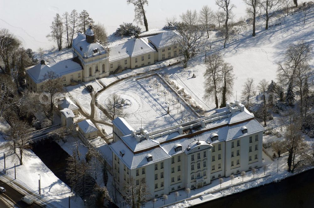 Berlin from above - Blick auf den winterlich verschneite Schloß Köpenick. Die spätere Schlossinsel Köpenick wurde schon zu urgeschichtlicher Zeit besiedelt und ist neben Spandau und Cölln eine der frühesten Siedlungsgebiete des heutigen Berlins. Hier fanden sich später slawische Burgwälle, eine slawische Burg entstand im 8. oder 9. Jahrhundert. Mehrere Nachfolgebauten folgten, darunter auch eine spätmittelalterliche Kastellburg. Der Slawenfürst Jaxa von Köpenick regierte hier im 12. Jahrhundert.Für Kurprinz Friedrich (später Kurfürst Friedrich III. von Brandenburg, dann auch König Friedrich I. in Preußen) wurde das Schloss ab 1677 erweitert. Als Architekt war hierbei Rutger van Langervelt, ein geborener Holländer aus Nimwegen, verantwortlich. Der nördliche Pavillon entstand in den Jahren 1679–1682. Der Architekt Johann Arnold Nering folgte van Langervelt 1684 beim Schlossbau und ließ den Wirtschaftsflügel mit der reformierten Schlosskirche (eingeweiht am 6. Januar 1685) und zuvor bereits das Hoftor (1682) entstehen. Friedrich bewohnte das Schloss später mit seiner Gemahlin Elisabeth Henriette von Hessen-Kassel, die den Anstoß zum Bau der Kirche gegeben haben soll.