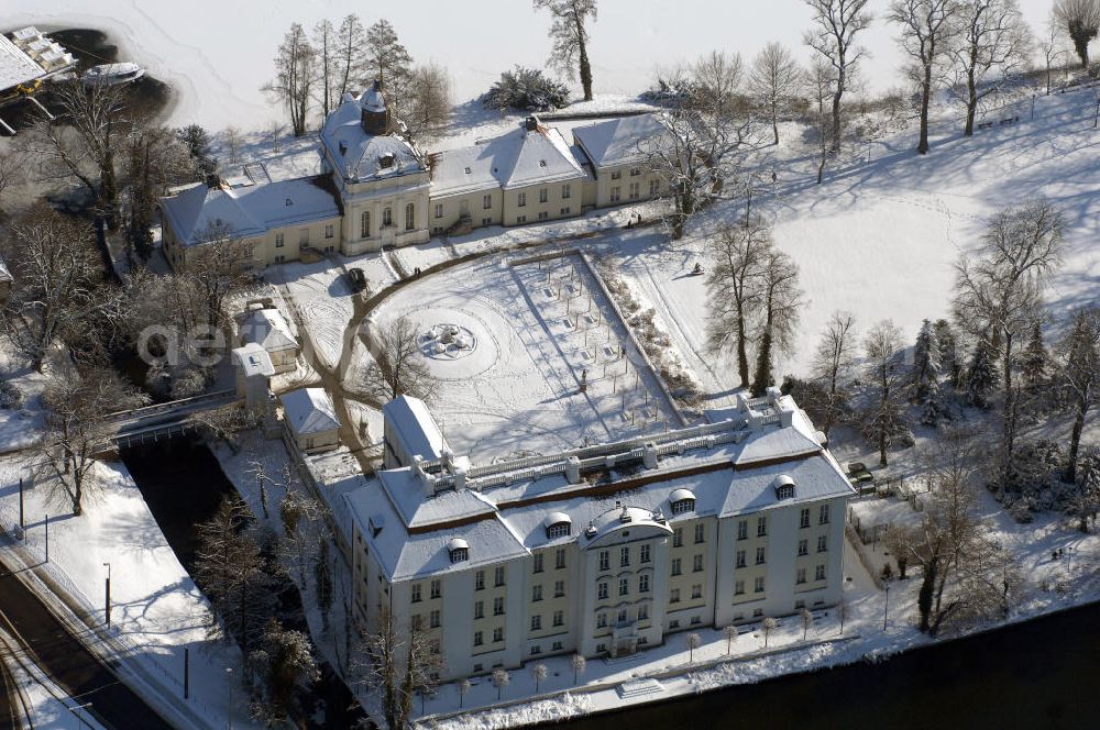 Berlin from the bird's eye view: Blick auf den winterlich verschneite Schloß Köpenick. Die spätere Schlossinsel Köpenick wurde schon zu urgeschichtlicher Zeit besiedelt und ist neben Spandau und Cölln eine der frühesten Siedlungsgebiete des heutigen Berlins. Hier fanden sich später slawische Burgwälle, eine slawische Burg entstand im 8. oder 9. Jahrhundert. Mehrere Nachfolgebauten folgten, darunter auch eine spätmittelalterliche Kastellburg. Der Slawenfürst Jaxa von Köpenick regierte hier im 12. Jahrhundert.Für Kurprinz Friedrich (später Kurfürst Friedrich III. von Brandenburg, dann auch König Friedrich I. in Preußen) wurde das Schloss ab 1677 erweitert. Als Architekt war hierbei Rutger van Langervelt, ein geborener Holländer aus Nimwegen, verantwortlich. Der nördliche Pavillon entstand in den Jahren 1679–1682. Der Architekt Johann Arnold Nering folgte van Langervelt 1684 beim Schlossbau und ließ den Wirtschaftsflügel mit der reformierten Schlosskirche (eingeweiht am 6. Januar 1685) und zuvor bereits das Hoftor (1682) entstehen. Friedrich bewohnte das Schloss später mit seiner Gemahlin Elisabeth Henriette von Hessen-Kassel, die den Anstoß zum Bau der Kirche gegeben haben soll.