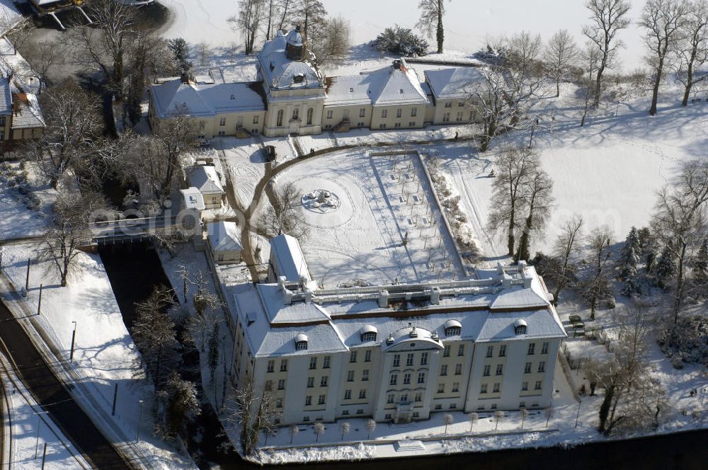 Aerial image Berlin - Blick auf den winterlich verschneite Schloß Köpenick. Die spätere Schlossinsel Köpenick wurde schon zu urgeschichtlicher Zeit besiedelt und ist neben Spandau und Cölln eine der frühesten Siedlungsgebiete des heutigen Berlins. Hier fanden sich später slawische Burgwälle, eine slawische Burg entstand im 8. oder 9. Jahrhundert. Mehrere Nachfolgebauten folgten, darunter auch eine spätmittelalterliche Kastellburg. Der Slawenfürst Jaxa von Köpenick regierte hier im 12. Jahrhundert.Für Kurprinz Friedrich (später Kurfürst Friedrich III. von Brandenburg, dann auch König Friedrich I. in Preußen) wurde das Schloss ab 1677 erweitert. Als Architekt war hierbei Rutger van Langervelt, ein geborener Holländer aus Nimwegen, verantwortlich. Der nördliche Pavillon entstand in den Jahren 1679–1682. Der Architekt Johann Arnold Nering folgte van Langervelt 1684 beim Schlossbau und ließ den Wirtschaftsflügel mit der reformierten Schlosskirche (eingeweiht am 6. Januar 1685) und zuvor bereits das Hoftor (1682) entstehen. Friedrich bewohnte das Schloss später mit seiner Gemahlin Elisabeth Henriette von Hessen-Kassel, die den Anstoß zum Bau der Kirche gegeben haben soll.