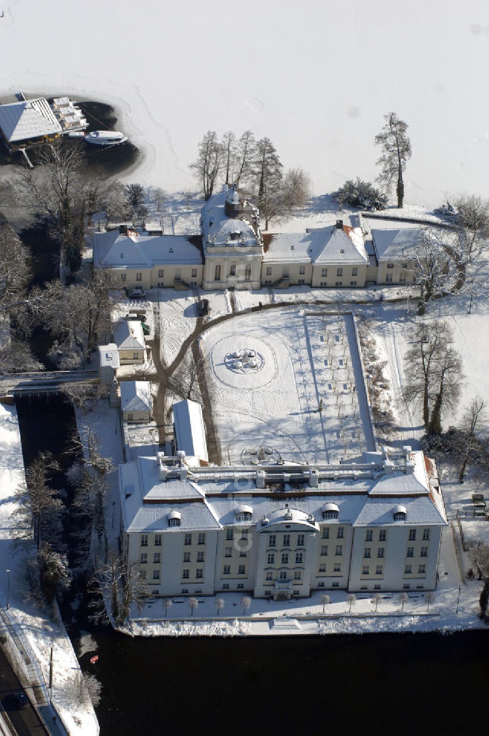 Aerial photograph Berlin - Blick auf den winterlich verschneite Schloß Köpenick. Die spätere Schlossinsel Köpenick wurde schon zu urgeschichtlicher Zeit besiedelt und ist neben Spandau und Cölln eine der frühesten Siedlungsgebiete des heutigen Berlins. Hier fanden sich später slawische Burgwälle, eine slawische Burg entstand im 8. oder 9. Jahrhundert. Mehrere Nachfolgebauten folgten, darunter auch eine spätmittelalterliche Kastellburg. Der Slawenfürst Jaxa von Köpenick regierte hier im 12. Jahrhundert.Für Kurprinz Friedrich (später Kurfürst Friedrich III. von Brandenburg, dann auch König Friedrich I. in Preußen) wurde das Schloss ab 1677 erweitert. Als Architekt war hierbei Rutger van Langervelt, ein geborener Holländer aus Nimwegen, verantwortlich. Der nördliche Pavillon entstand in den Jahren 1679–1682. Der Architekt Johann Arnold Nering folgte van Langervelt 1684 beim Schlossbau und ließ den Wirtschaftsflügel mit der reformierten Schlosskirche (eingeweiht am 6. Januar 1685) und zuvor bereits das Hoftor (1682) entstehen. Friedrich bewohnte das Schloss später mit seiner Gemahlin Elisabeth Henriette von Hessen-Kassel, die den Anstoß zum Bau der Kirche gegeben haben soll.