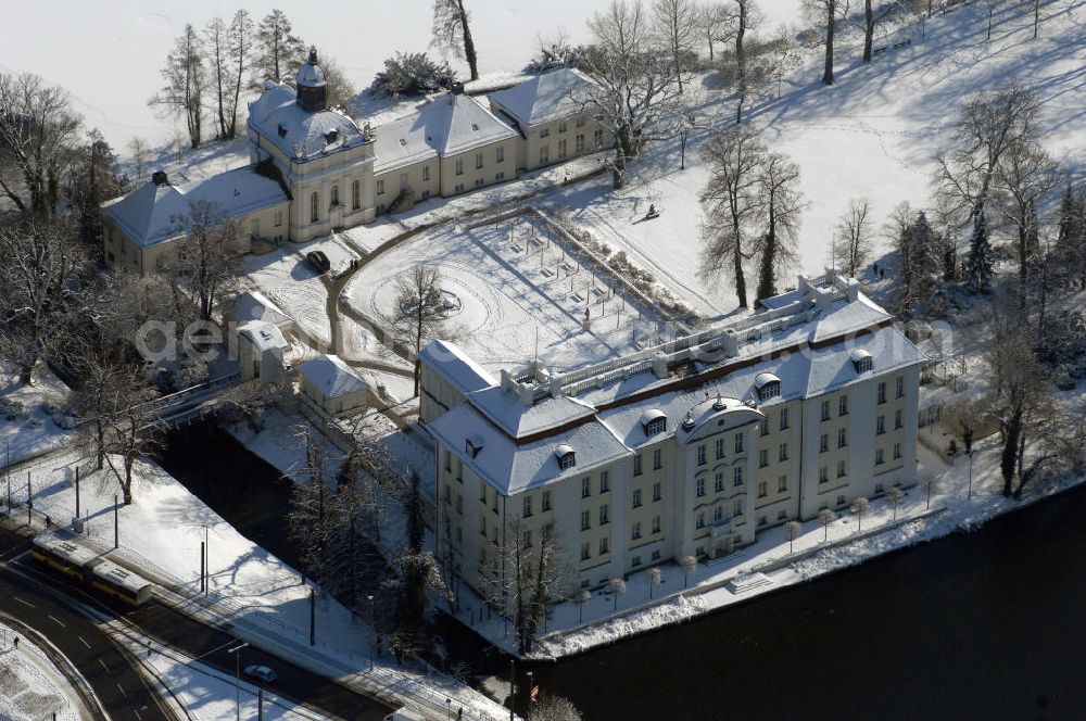 Berlin from above - Blick auf den winterlich verschneite Schloß Köpenick. Die spätere Schlossinsel Köpenick wurde schon zu urgeschichtlicher Zeit besiedelt und ist neben Spandau und Cölln eine der frühesten Siedlungsgebiete des heutigen Berlins. Hier fanden sich später slawische Burgwälle, eine slawische Burg entstand im 8. oder 9. Jahrhundert. Mehrere Nachfolgebauten folgten, darunter auch eine spätmittelalterliche Kastellburg. Der Slawenfürst Jaxa von Köpenick regierte hier im 12. Jahrhundert.Für Kurprinz Friedrich (später Kurfürst Friedrich III. von Brandenburg, dann auch König Friedrich I. in Preußen) wurde das Schloss ab 1677 erweitert. Als Architekt war hierbei Rutger van Langervelt, ein geborener Holländer aus Nimwegen, verantwortlich. Der nördliche Pavillon entstand in den Jahren 1679–1682. Der Architekt Johann Arnold Nering folgte van Langervelt 1684 beim Schlossbau und ließ den Wirtschaftsflügel mit der reformierten Schlosskirche (eingeweiht am 6. Januar 1685) und zuvor bereits das Hoftor (1682) entstehen. Friedrich bewohnte das Schloss später mit seiner Gemahlin Elisabeth Henriette von Hessen-Kassel, die den Anstoß zum Bau der Kirche gegeben haben soll.