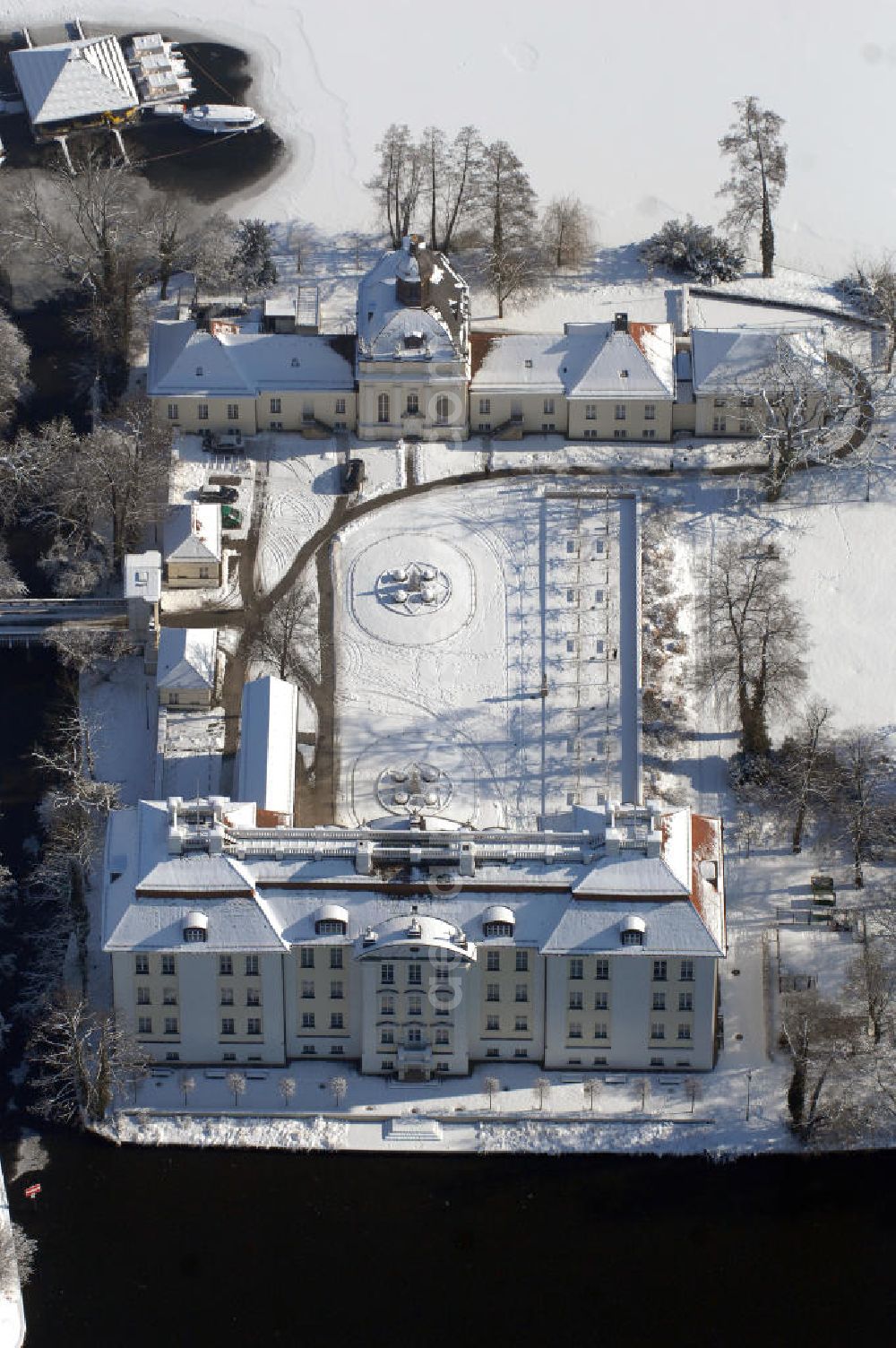 Berlin from the bird's eye view: Blick auf den winterlich verschneite Schloß Köpenick. Die spätere Schlossinsel Köpenick wurde schon zu urgeschichtlicher Zeit besiedelt und ist neben Spandau und Cölln eine der frühesten Siedlungsgebiete des heutigen Berlins. Hier fanden sich später slawische Burgwälle, eine slawische Burg entstand im 8. oder 9. Jahrhundert. Mehrere Nachfolgebauten folgten, darunter auch eine spätmittelalterliche Kastellburg. Der Slawenfürst Jaxa von Köpenick regierte hier im 12. Jahrhundert.Für Kurprinz Friedrich (später Kurfürst Friedrich III. von Brandenburg, dann auch König Friedrich I. in Preußen) wurde das Schloss ab 1677 erweitert. Als Architekt war hierbei Rutger van Langervelt, ein geborener Holländer aus Nimwegen, verantwortlich. Der nördliche Pavillon entstand in den Jahren 1679–1682. Der Architekt Johann Arnold Nering folgte van Langervelt 1684 beim Schlossbau und ließ den Wirtschaftsflügel mit der reformierten Schlosskirche (eingeweiht am 6. Januar 1685) und zuvor bereits das Hoftor (1682) entstehen. Friedrich bewohnte das Schloss später mit seiner Gemahlin Elisabeth Henriette von Hessen-Kassel, die den Anstoß zum Bau der Kirche gegeben haben soll.