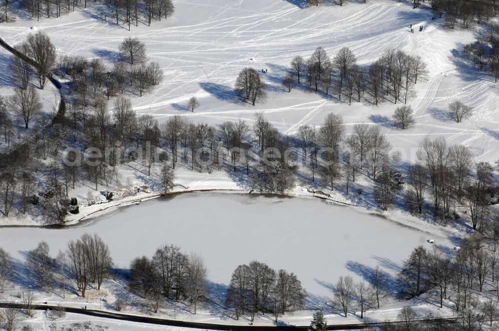 Berlin from above - Blick auf die winterlich verschneiten Britzer Garten.Der Britzer Garten, benannt nach dem Berliner Ortsteil Britz, wurde für die Bundesgartenschau 1985 angelegt, um der damals vom Umland abgeschnittenen Bevölkerung im Süden West-Berlins einen neuen Landschaftspark zu bieten.Der Britzer Garten wurde auf Ackerflächen und Kleingartenkolonien angelegt; weitestgehend wurden jedoch vorhandene Kleingartenkolonien erhalten. Er befindet sich am südwestlichen Rand des damaligen Berliner Bezirkes Neukölln und grenzt an den Bezirk Tempelhof mit dem Ortsteil Mariendorf an. Er wird durch die Hauptstraßenachsen Mariendorfer Damm, Mohriner Allee, Buckower Damm und Alt-Buckow / Marienfelder Allee eingerahmt. Am Rand dieser Hauptstraßen befindet sich meist offene Wohnbebauung. Noch im Eröffnungsjahr 1985 bestand die planerische Absicht, eine Verlängerung der Berliner Stadtautobahn von der Anschlussstelle Gradestraße durch das Gartengelände hindurch bis zur Berliner Stadtgrenze zu bauen, um dort einen neuen Grenzübergang mit Weiterführung zum Berliner Ring einrichten zu können.