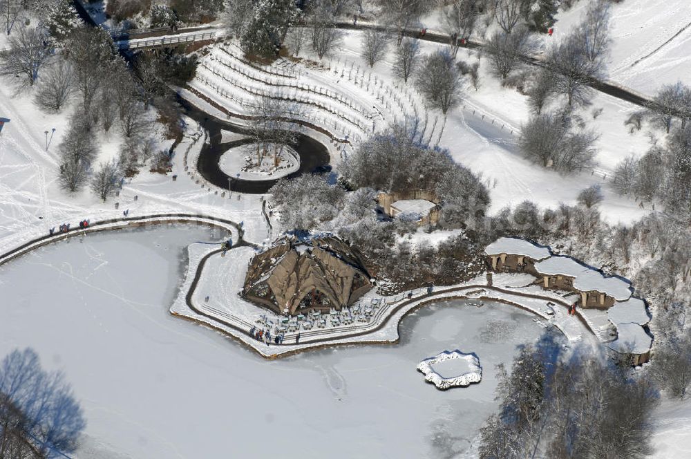 Berlin from the bird's eye view: Blick auf die winterlich verschneiten Britzer Garten.Der Britzer Garten, benannt nach dem Berliner Ortsteil Britz, wurde für die Bundesgartenschau 1985 angelegt, um der damals vom Umland abgeschnittenen Bevölkerung im Süden West-Berlins einen neuen Landschaftspark zu bieten.Der Britzer Garten wurde auf Ackerflächen und Kleingartenkolonien angelegt; weitestgehend wurden jedoch vorhandene Kleingartenkolonien erhalten. Er befindet sich am südwestlichen Rand des damaligen Berliner Bezirkes Neukölln und grenzt an den Bezirk Tempelhof mit dem Ortsteil Mariendorf an. Er wird durch die Hauptstraßenachsen Mariendorfer Damm, Mohriner Allee, Buckower Damm und Alt-Buckow / Marienfelder Allee eingerahmt. Am Rand dieser Hauptstraßen befindet sich meist offene Wohnbebauung. Noch im Eröffnungsjahr 1985 bestand die planerische Absicht, eine Verlängerung der Berliner Stadtautobahn von der Anschlussstelle Gradestraße durch das Gartengelände hindurch bis zur Berliner Stadtgrenze zu bauen, um dort einen neuen Grenzübergang mit Weiterführung zum Berliner Ring einrichten zu können.