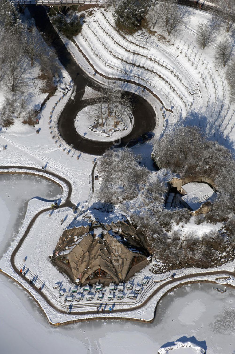 Berlin from the bird's eye view: Blick auf die winterlich verschneiten Britzer Garten.Der Britzer Garten, benannt nach dem Berliner Ortsteil Britz, wurde für die Bundesgartenschau 1985 angelegt, um der damals vom Umland abgeschnittenen Bevölkerung im Süden West-Berlins einen neuen Landschaftspark zu bieten.Der Britzer Garten wurde auf Ackerflächen und Kleingartenkolonien angelegt; weitestgehend wurden jedoch vorhandene Kleingartenkolonien erhalten. Er befindet sich am südwestlichen Rand des damaligen Berliner Bezirkes Neukölln und grenzt an den Bezirk Tempelhof mit dem Ortsteil Mariendorf an. Er wird durch die Hauptstraßenachsen Mariendorfer Damm, Mohriner Allee, Buckower Damm und Alt-Buckow / Marienfelder Allee eingerahmt. Am Rand dieser Hauptstraßen befindet sich meist offene Wohnbebauung. Noch im Eröffnungsjahr 1985 bestand die planerische Absicht, eine Verlängerung der Berliner Stadtautobahn von der Anschlussstelle Gradestraße durch das Gartengelände hindurch bis zur Berliner Stadtgrenze zu bauen, um dort einen neuen Grenzübergang mit Weiterführung zum Berliner Ring einrichten zu können.