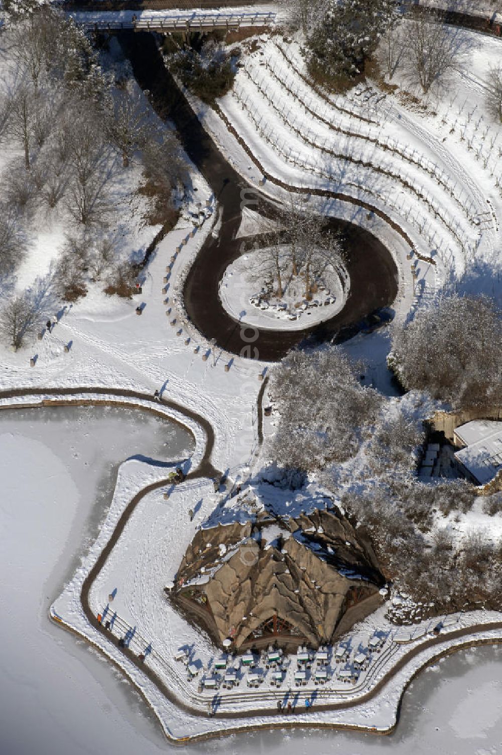 Aerial image Berlin - Blick auf die winterlich verschneiten Britzer Garten.Der Britzer Garten, benannt nach dem Berliner Ortsteil Britz, wurde für die Bundesgartenschau 1985 angelegt, um der damals vom Umland abgeschnittenen Bevölkerung im Süden West-Berlins einen neuen Landschaftspark zu bieten.Der Britzer Garten wurde auf Ackerflächen und Kleingartenkolonien angelegt; weitestgehend wurden jedoch vorhandene Kleingartenkolonien erhalten. Er befindet sich am südwestlichen Rand des damaligen Berliner Bezirkes Neukölln und grenzt an den Bezirk Tempelhof mit dem Ortsteil Mariendorf an. Er wird durch die Hauptstraßenachsen Mariendorfer Damm, Mohriner Allee, Buckower Damm und Alt-Buckow / Marienfelder Allee eingerahmt. Am Rand dieser Hauptstraßen befindet sich meist offene Wohnbebauung. Noch im Eröffnungsjahr 1985 bestand die planerische Absicht, eine Verlängerung der Berliner Stadtautobahn von der Anschlussstelle Gradestraße durch das Gartengelände hindurch bis zur Berliner Stadtgrenze zu bauen, um dort einen neuen Grenzübergang mit Weiterführung zum Berliner Ring einrichten zu können.