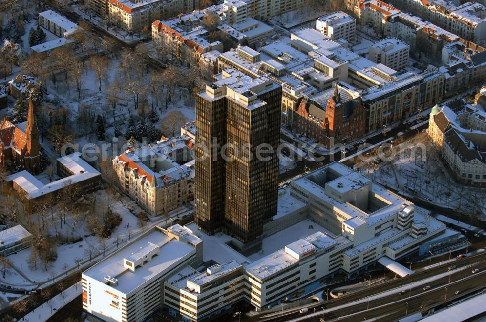 Berlin from the bird's eye view: Blick auf den winterlich verschneiten Steglitzer Kreisel, einen Gebäudekomplex mit Bürohochhaus im Berliner Ortsteil Steglitz gegenüber dem Rathaus Steglitz. Den Hauptteil des Gebäudes bildet ein 119 Meter hohes Verwaltungshochhaus mit 27 Stockwerken. Am 27. Juni 2006 hatte der Berliner Senat beschlossen, das Bürohochhaus aufzugeben und die dort beschäftigten Mitarbeiter des Bezirksamts Steglitz-Zehlendorf in an deren landeseigenen Immobilien unterzubringen. Zum 23. November 2007 wurde das Haus geräumt. Die zwei Jahre dauernden Sanierungsarbeiten beginnen frühestens 2009, nachdem die Berliner Finanzverwaltung und der Liegenschaftsfonds nochmals vergeblich versucht hatten, das Gebäude im jetzigen Zustand zu verkaufen. Die weitere Nutzung ist ungeklärt, neben dem Verkauf an Wolfgang Gerbere Investoren wird auch ein Abriss nicht ausgeschlossen, der jedoch in der Öffentlichkeit umstritten ist.