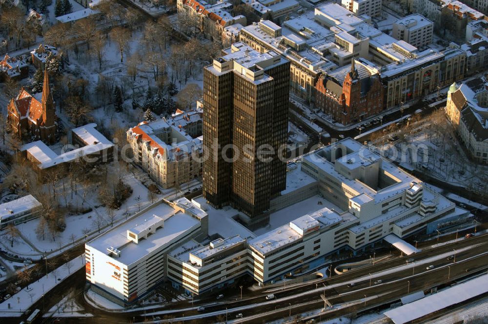 Aerial image Berlin - Blick auf den winterlich verschneiten Steglitzer Kreisel, einen Gebäudekomplex mit Bürohochhaus im Berliner Ortsteil Steglitz gegenüber dem Rathaus Steglitz. Den Hauptteil des Gebäudes bildet ein 119 Meter hohes Verwaltungshochhaus mit 27 Stockwerken. Am 27. Juni 2006 hatte der Berliner Senat beschlossen, das Bürohochhaus aufzugeben und die dort beschäftigten Mitarbeiter des Bezirksamts Steglitz-Zehlendorf in an deren landeseigenen Immobilien unterzubringen. Zum 23. November 2007 wurde das Haus geräumt. Die zwei Jahre dauernden Sanierungsarbeiten beginnen frühestens 2009, nachdem die Berliner Finanzverwaltung und der Liegenschaftsfonds nochmals vergeblich versucht hatten, das Gebäude im jetzigen Zustand zu verkaufen. Die weitere Nutzung ist ungeklärt, neben dem Verkauf an Wolfgang Gerbere Investoren wird auch ein Abriss nicht ausgeschlossen, der jedoch in der Öffentlichkeit umstritten ist.