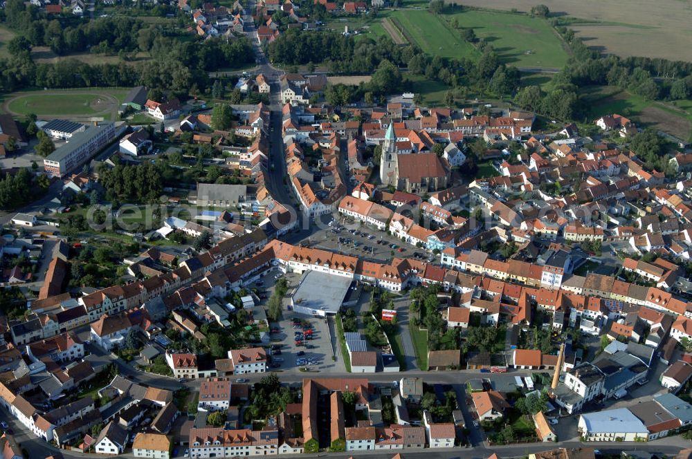 SPREMBERG from above - Blick auf das Wohngebiet an der Langen Straße und Am Markt mit der Kreuzkirche. Spremberg ist eine Stadt im brandenburgischen Landkreis Spree-Neiße. Nach bisher bekannten Quellen wurde Spremberg erstmals 1301 erwähnt. Spremberg liegt an der Spree, dadurch lässt sich auch der Name ableiten: aus „Spree am Berg“ wurde Spremberg. Für die Evangelische Kreuzkirche, eine spätgotische dreischiffige Backstein-Hallenkirche, wird als Baujahr 1509 angenommen. Diese Annahme beruht auf die in einem Pfeiler der Apsis eingebrachten Jahreszahl 1509. Die Kreuzkirche ist ein Nachfolgebau, der teilweise auf den Fundamenten einer an dieser Stelle bereits früher vorhandenen Kirche errichtet wurde. Kontakt: Stadtverwaltung Spremberg, Referent des Bürgermeisters, Am Markt 1, 03130 Spremberg, Tel. +49 (0)3563 340 101, e-mail: bm-referent@stadt-spremberg.de; Kontakt Kreuzkirche Spremberg: Kirchplatz 5, 03130 Spremberg, Tel. +49 (0)3563 2032