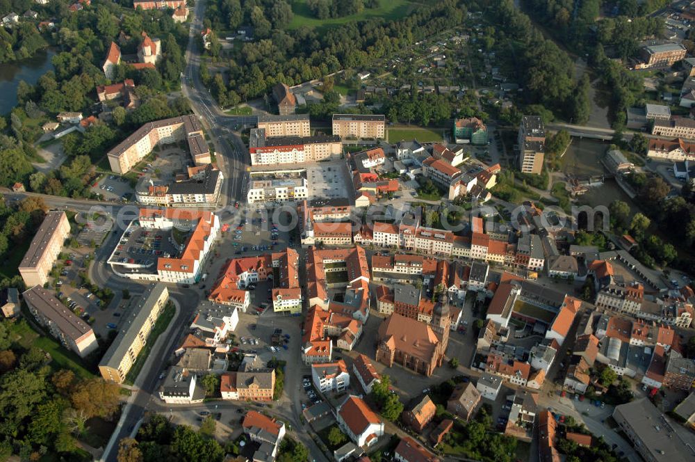 SPREMBERG from above - Blick auf das Wohngebiet an der Langen Straße und Am Markt mit der Kreuzkirche. Spremberg ist eine Stadt im brandenburgischen Landkreis Spree-Neiße. Nach bisher bekannten Quellen wurde Spremberg erstmals 1301 erwähnt. Spremberg liegt an der Spree, dadurch lässt sich auch der Name ableiten: aus „Spree am Berg“ wurde Spremberg. Für die Evangelische Kreuzkirche, eine spätgotische dreischiffige Backstein-Hallenkirche, wird als Baujahr 1509 angenommen. Diese Annahme beruht auf die in einem Pfeiler der Apsis eingebrachten Jahreszahl 1509. Die Kreuzkirche ist ein Nachfolgebau, der teilweise auf den Fundamenten einer an dieser Stelle bereits früher vorhandenen Kirche errichtet wurde. Kontakt: Stadtverwaltung Spremberg, Referent des Bürgermeisters, Am Markt 1, 03130 Spremberg, Tel. +49 (0)3563 340 101, e-mail: bm-referent@stadt-spremberg.de; Kontakt Kreuzkirche Spremberg: Kirchplatz 5, 03130 Spremberg, Tel. +49 (0)3563 2032