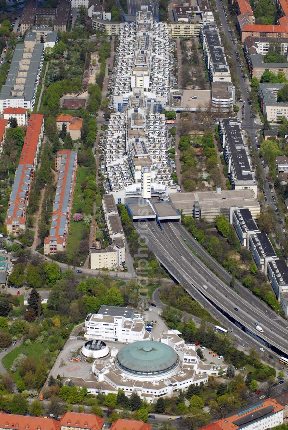 Aerial photograph Berlin - Wilmersdorf - Blick auf den Wohnpark an der Schlangenbader Strasse in Wilmersdorf. 1970/1971 begannen die ersten Bauarbeiten des südlichen Abzweigs (A 104) der Stadtautobahn A 100. Auf einem Areal von etwa 44.000 m², welches im westlichen Teil die Autobahn A 104 überschneidet, konnte nun die Autobahnüberbauung Schlangenbader Straße geplant werden. Zunächst fungierte das Projekt unter dem Namen Wohnpark Wilmersdorf.Die heutige Autobahnüberbauung umschließt die Autobahn A 104 auf einer Länge von 600 m in ihrem Nord-Süd-Verlauf und verläuft analog der Fahrbahn in leichtem Winkel gebogen. Die Erbauung des Gesamtprojekts fand zwischen 1976 und 1980 statt. Die Bauausführung erfolgte durch mehrere Firmen in einer Arbeitsgemeinschaft. Beteiligt waren die Firmen Burgert-Neue Bauhütte AG, Ed.Züblin AG, Schälerbau Berlin, Bruno Ansorge, Lindow & Co, Richter & Schädel, Sager & Woerner(SAWOE), Anton Schmittlein AG, Gottlieb Tesch GmbH, Karl Tobias GmbH, F.C. Trapp und Wiemer & Trachte