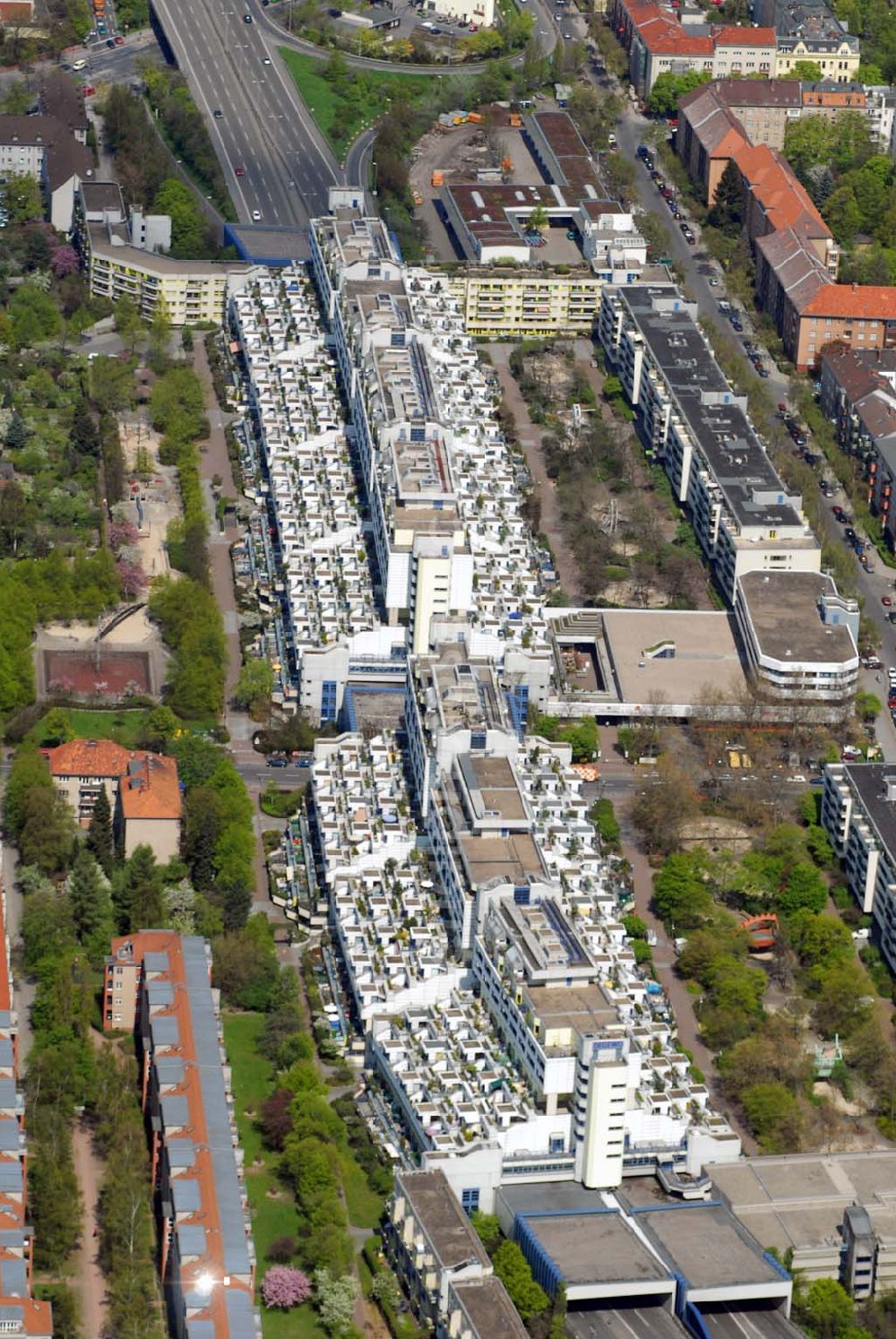 Berlin - Wilmersdorf from the bird's eye view: Blick auf den Wohnpark an der Schlangenbader Strasse in Wilmersdorf. 1970/1971 begannen die ersten Bauarbeiten des südlichen Abzweigs (A 104) der Stadtautobahn A 100. Auf einem Areal von etwa 44.000 m², welches im westlichen Teil die Autobahn A 104 überschneidet, konnte nun die Autobahnüberbauung Schlangenbader Straße geplant werden. Zunächst fungierte das Projekt unter dem Namen Wohnpark Wilmersdorf.Die heutige Autobahnüberbauung umschließt die Autobahn A 104 auf einer Länge von 600 m in ihrem Nord-Süd-Verlauf und verläuft analog der Fahrbahn in leichtem Winkel gebogen. Die Erbauung des Gesamtprojekts fand zwischen 1976 und 1980 statt. Die Bauausführung erfolgte durch mehrere Firmen in einer Arbeitsgemeinschaft. Beteiligt waren die Firmen Burgert-Neue Bauhütte AG, Ed.Züblin AG, Schälerbau Berlin, Bruno Ansorge, Lindow & Co, Richter & Schädel, Sager & Woerner(SAWOE), Anton Schmittlein AG, Gottlieb Tesch GmbH, Karl Tobias GmbH, F.C. Trapp und Wiemer & Trachte