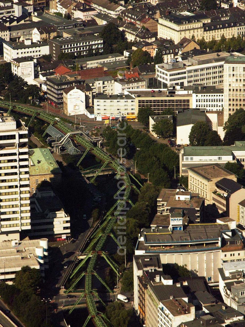 Aerial photograph Wuppertal - 29.08.2005 Wuppertal, Die Wuppertaler Schwebebahn, die weltweit als einzigartig gilt, ist ein um 1900 erbautes, 1901 freigegebenes und bis heute in Betrieb stehendes Nahverkehrssystem im Stadtbereich von Wuppertal. Die Hängebahn fährt auf einer 13,3 km langen Strecke in etwa zwölf Metern Höhe über dem Flussbett der Wupper bzw. in etwa acht m Höhe über Stadtstraßen zwischen den Endhaltestellen von Wuppertal-Oberbarmen und Wuppertal-Vohwinkel. Die Gesamtfahrstrecke mit Ein- und Aussteigestopps an 20 Haltestellen wird in knapp 35 Minuten zurück gelegt.