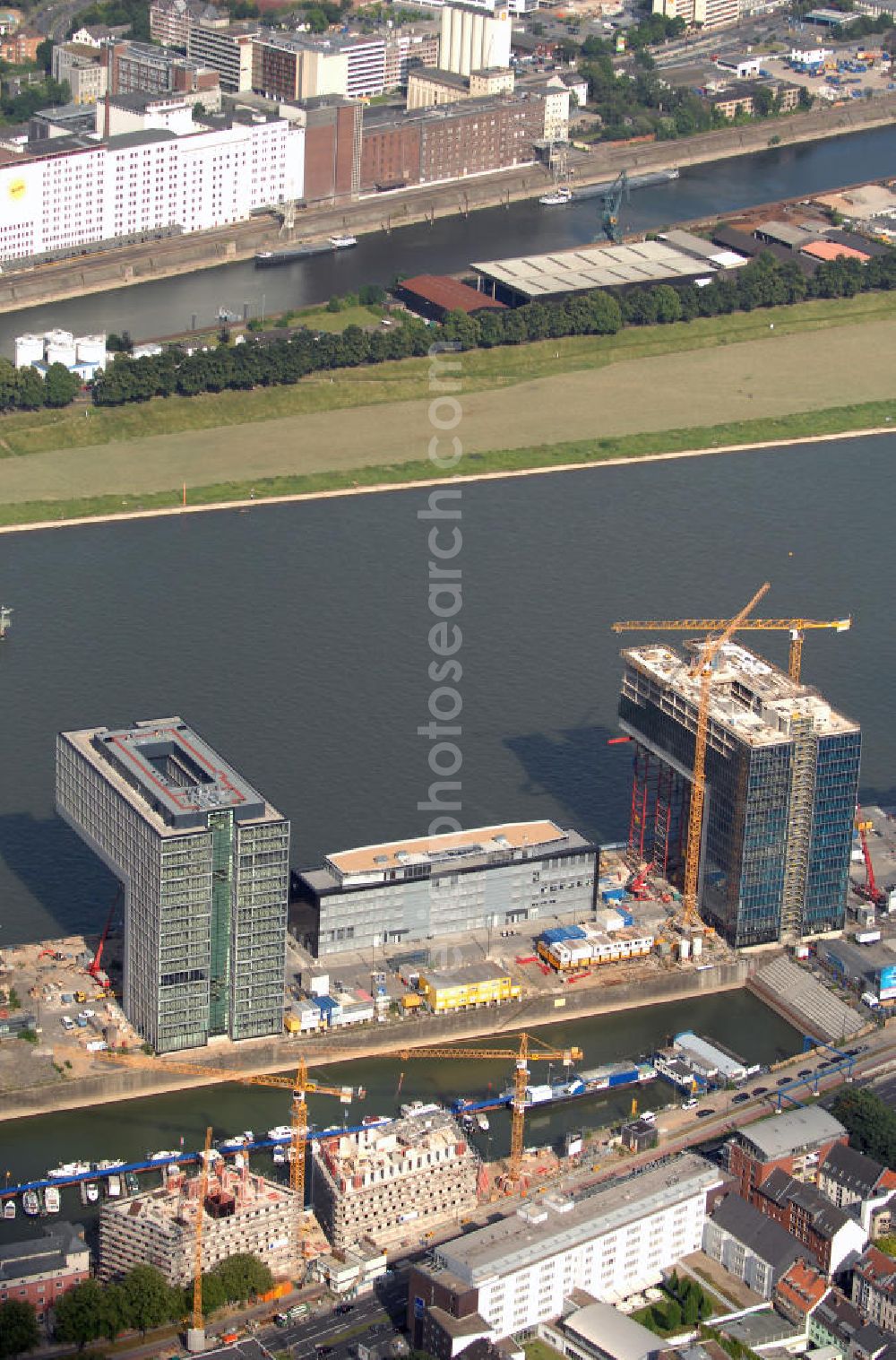 Köln from the bird's eye view: Blick auf zwei der drei Kranhäuser am Kölner Rheinauhafen. Die Bürogebäude sind alle ca. 60 Meter hoch, 34 Meter breit und haben eine Länge von 70 Metern. Entworfen wurden sie vom Architekturbüro BRT Bothe Richter Teherani. Das mittlere Kranhaus, das Kranhaus1 (hier links im Bild), war das erste, der drei Bürohäuser, das gebaut wurde und setzte den Anstoß für das nördliche und südliche Kranhaus. Kontakt: BRT Bothe Richter Teherani Architekten, Oberbaumbrücke 1 20457 Hamburg Bürohaus Deichtor, Tel. +49(0)40 24842 0, Fax +49(0)40 24842 222, Email: office@brt.de