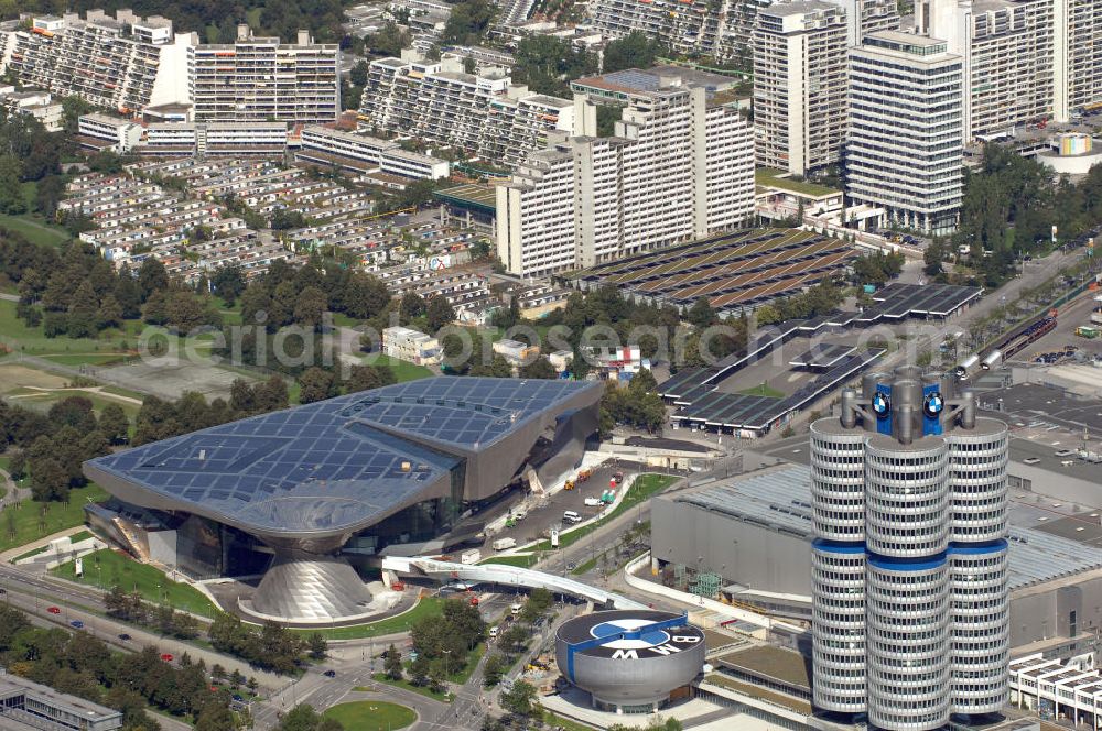 Aerial image München - Der BMW Vierzylinder (auch: BMW-Turm, BMW-Hochhaus) ist das Hauptverwaltungsgebäude und Wahrzeichen des Autoherstellers BMW in München. Die BMW Welt wurde von den Architekten Coop Himmelb(l)au für BMW errichtet. Auf dem Dach ist eine Solaranlage mit 800 KW Leistung installiert. Genutzt wird das Gebäude für Ausstellungen rund um das Thema BMW. Weitere Informationen unter: http://