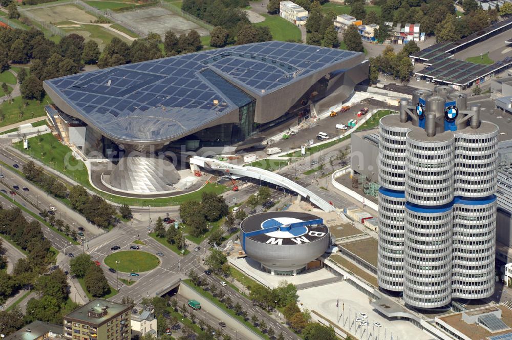 Aerial photograph München - Der BMW Vierzylinder (auch: BMW-Turm, BMW-Hochhaus) ist das Hauptverwaltungsgebäude und Wahrzeichen des Autoherstellers BMW in München. Die BMW Welt wurde von den Architekten Coop Himmelb(l)au für BMW errichtet. Auf dem Dach ist eine Solaranlage mit 800 KW Leistung installiert. Genutzt wird das Gebäude für Ausstellungen rund um das Thema BMW. Weitere Informationen unter: http://