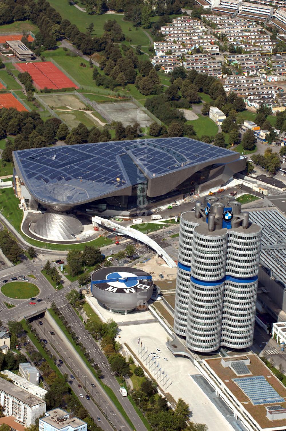 München from the bird's eye view: Der BMW Vierzylinder (auch: BMW-Turm, BMW-Hochhaus) ist das Hauptverwaltungsgebäude und Wahrzeichen des Autoherstellers BMW in München. Die BMW Welt wurde von den Architekten Coop Himmelb(l)au für BMW errichtet. Auf dem Dach ist eine Solaranlage mit 800 KW Leistung installiert. Genutzt wird das Gebäude für Ausstellungen rund um das Thema BMW. Weitere Informationen unter: http://