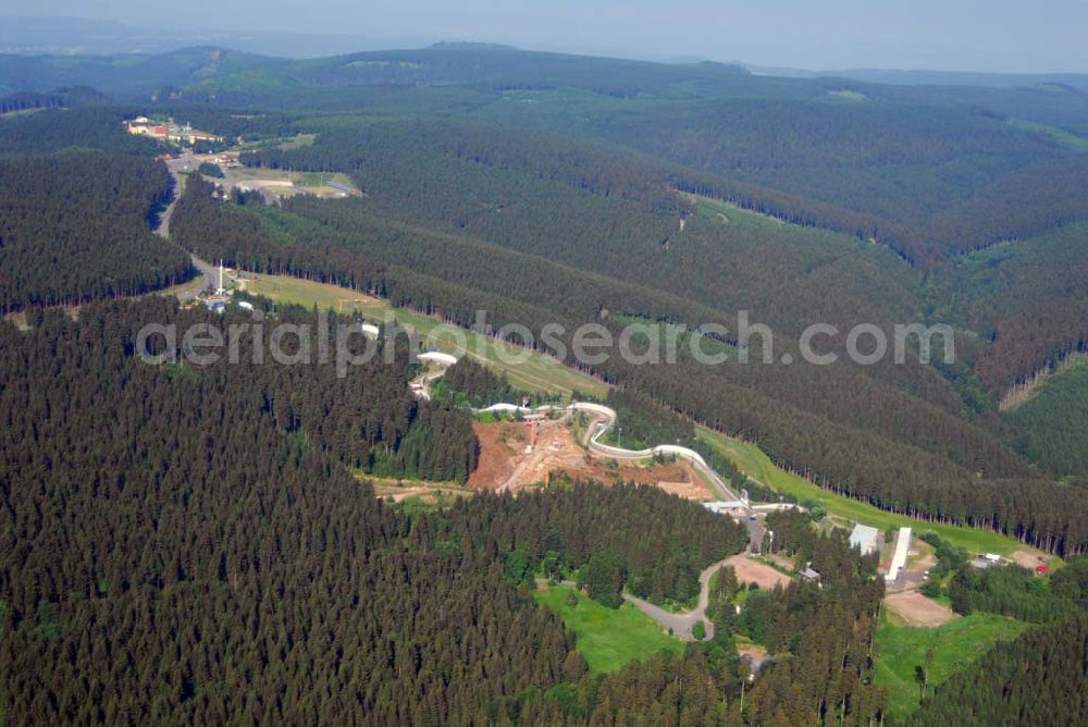 Oberhof from above - Blick auf die Bob- und Rodelbahn BSR Rennsteig Oberhof e.V. in der Gräfenrodaer Straße 2 in 98559 Oberhof. Fon: 036842) 212 02 Mail: mail@bsr-oberhof.de. Ziel des ca. 280 Mitglieder starken Vereins ist es, den Kufensport in den Disziplinen Bob, Skeleton und Renn- rodeln intensiv zu fördern. Gleichzeitig ist der BSR professioneller Ausrichter vieler internationaler Wettkämpfe in der berühmten Oberhofer Kunsteis- schlange. Seit 1973 werden hier so hochkarätige Wettbewerbe, Weltmeisterschaften (1973 und 1985), Europameister- schaften (1979 und 1998), jährliche Weltcups sowie unzählige nationale Sportveranstaltungen, ausgetragen.